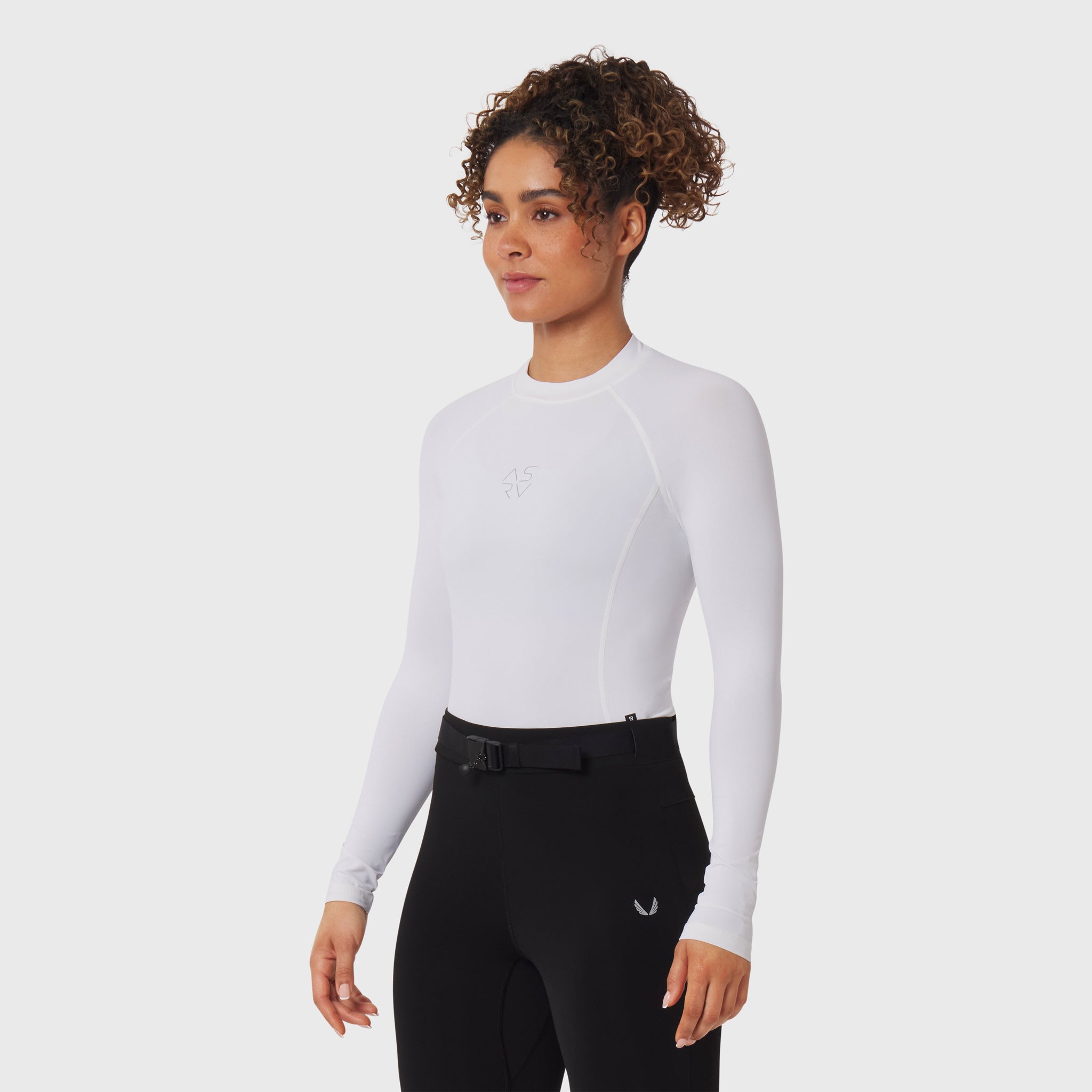 White LYCRA® ADAPTIV baselayer longsleeve worn with black pants, front view on model