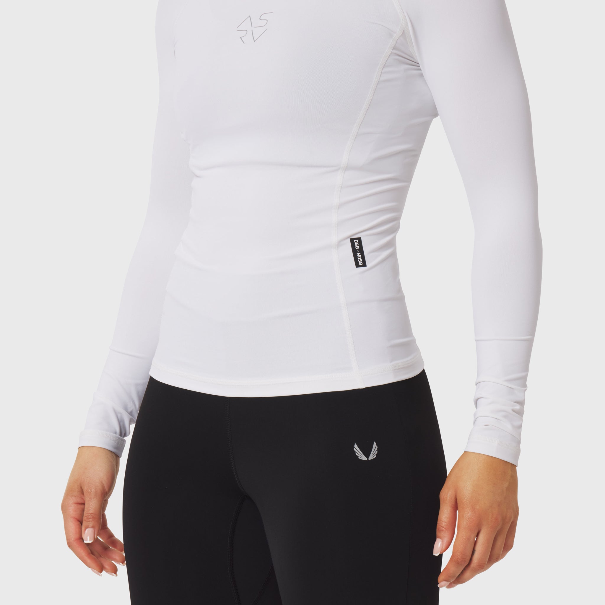 LYCRA® ADAPTIV Baselayer Longsleeve in white, worn with black leggings, side view