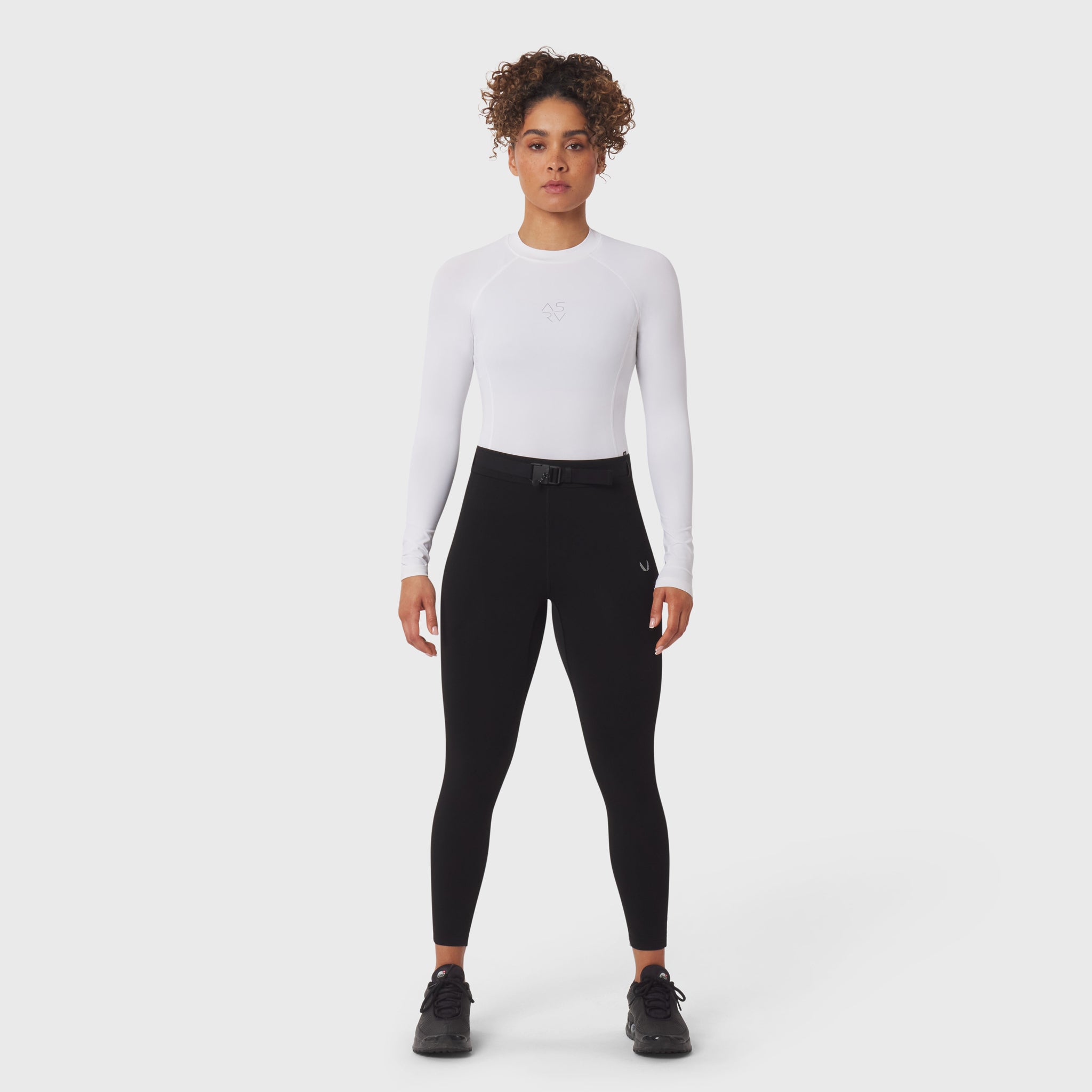 LYCRA® ADAPTIV Baselayer Longsleeve in white, worn with black leggings, front view on model