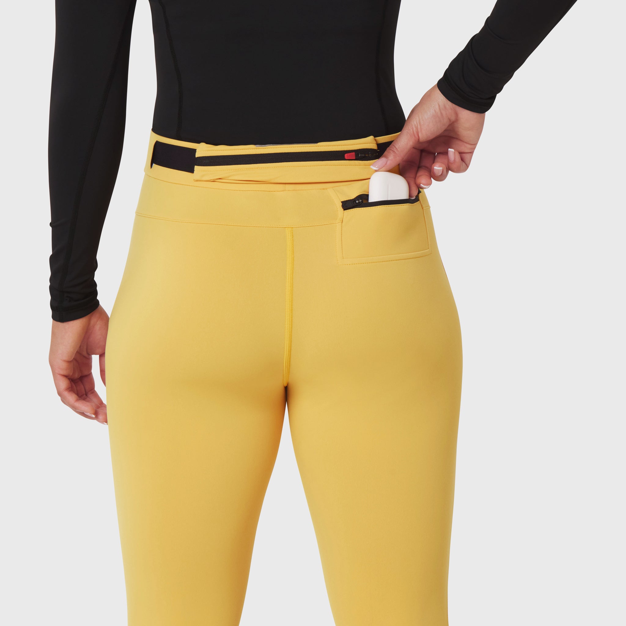 W059 Hybrid Belt-Pack Run Legging in amber yellow worn by model, back view showing belt pack