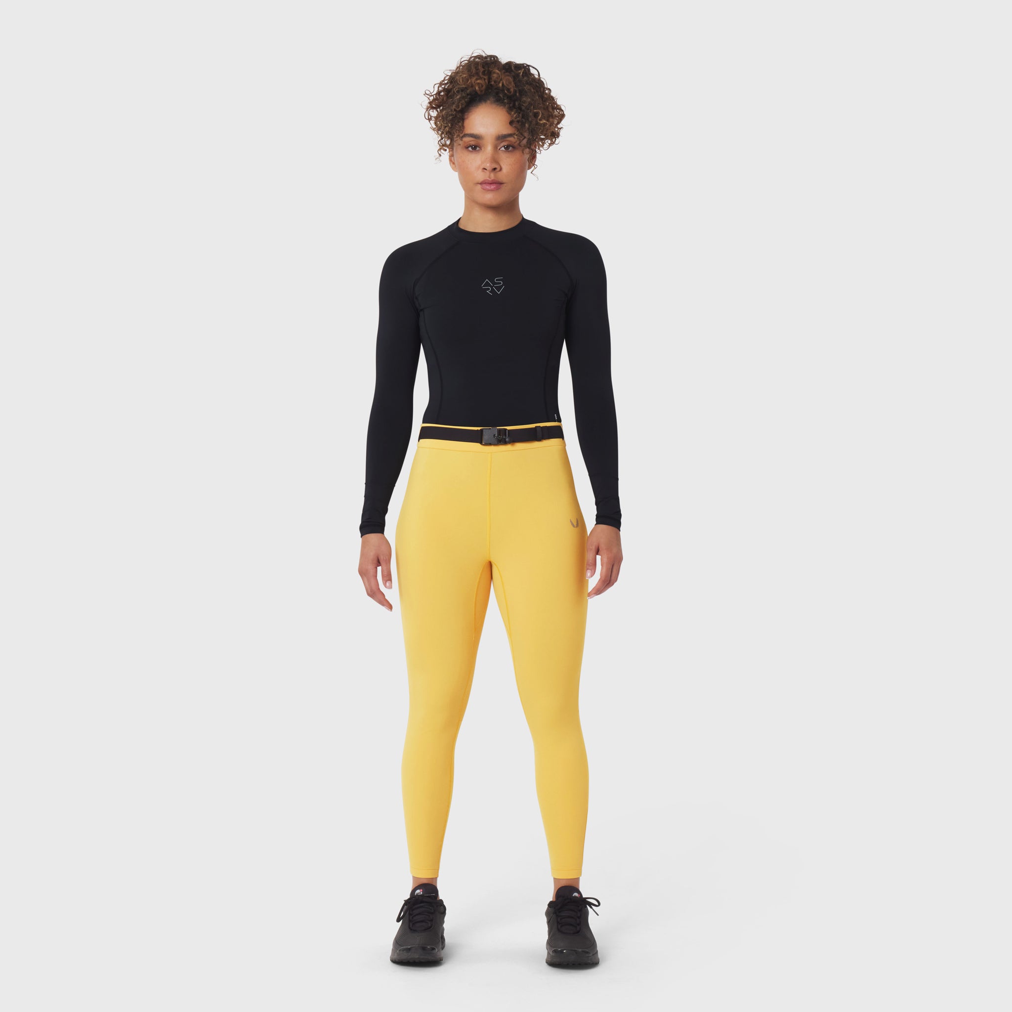 W059 Hybrid Belt-Pack Run Legging in amber yellow, worn with black long-sleeve top and black sneakers