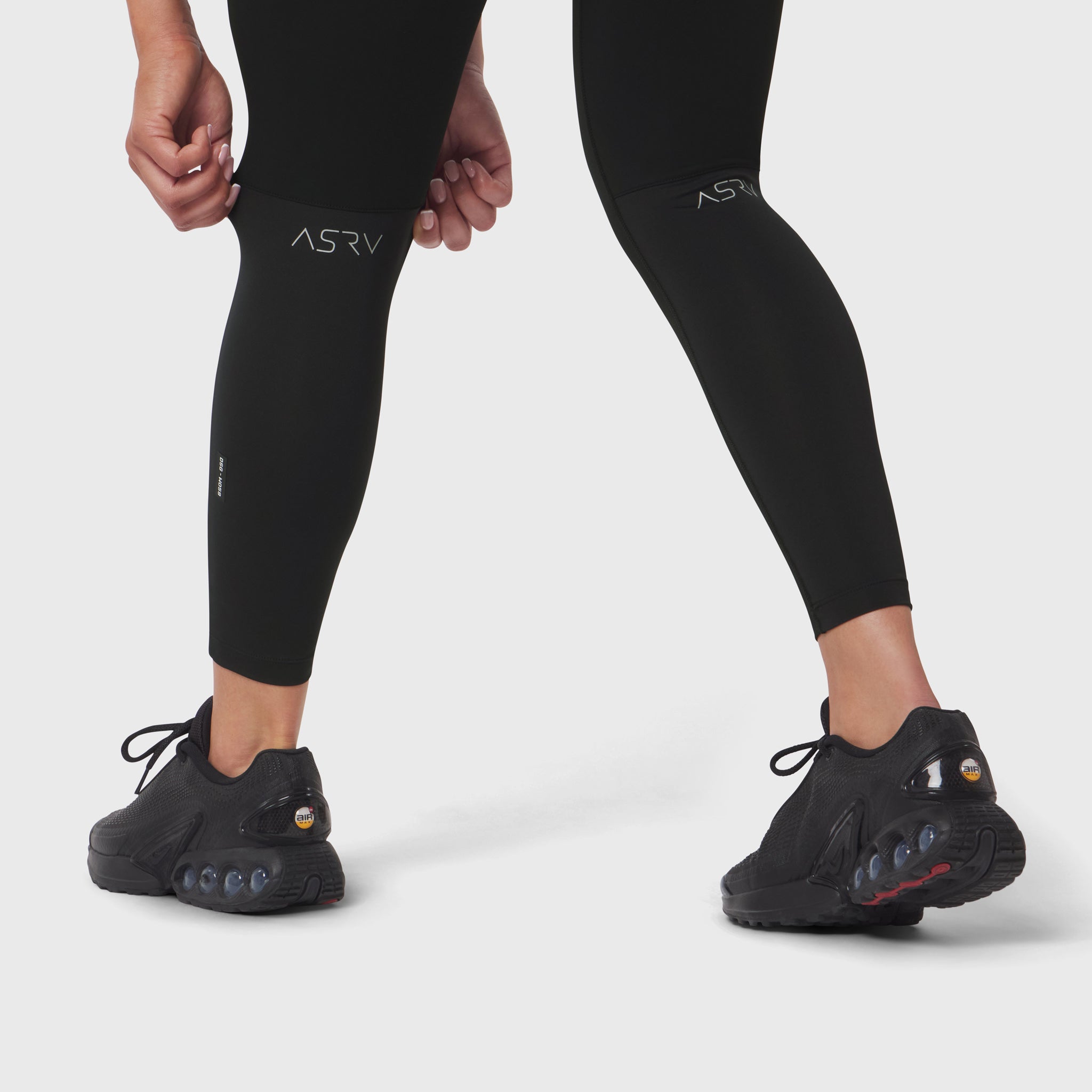 W059 Hybrid Belt-Pack Run Legging in black, worn by model from waist down with black sneakers