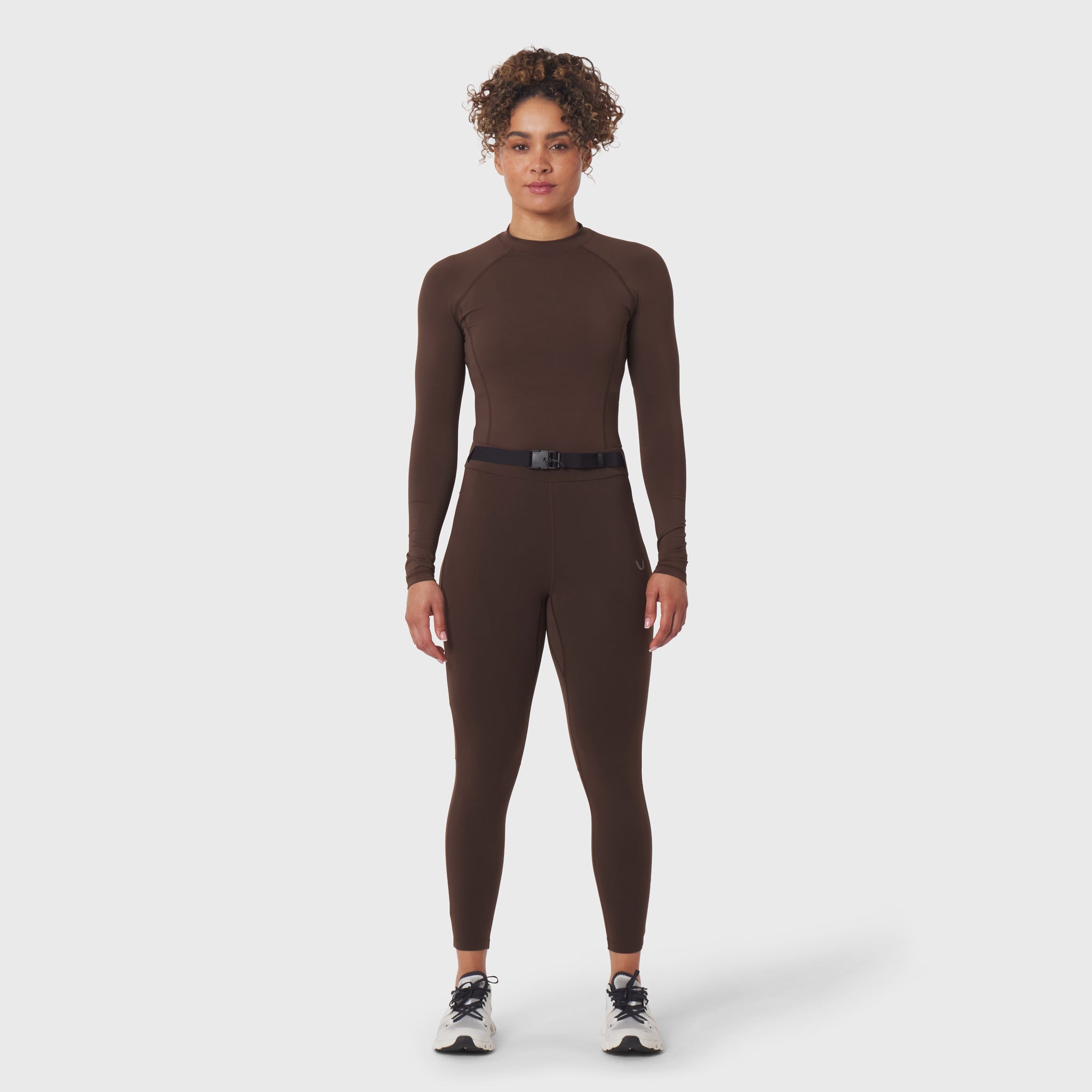 W059 Hybrid Belt-Pack Run Legging in dark earth, worn by model standing facing camera