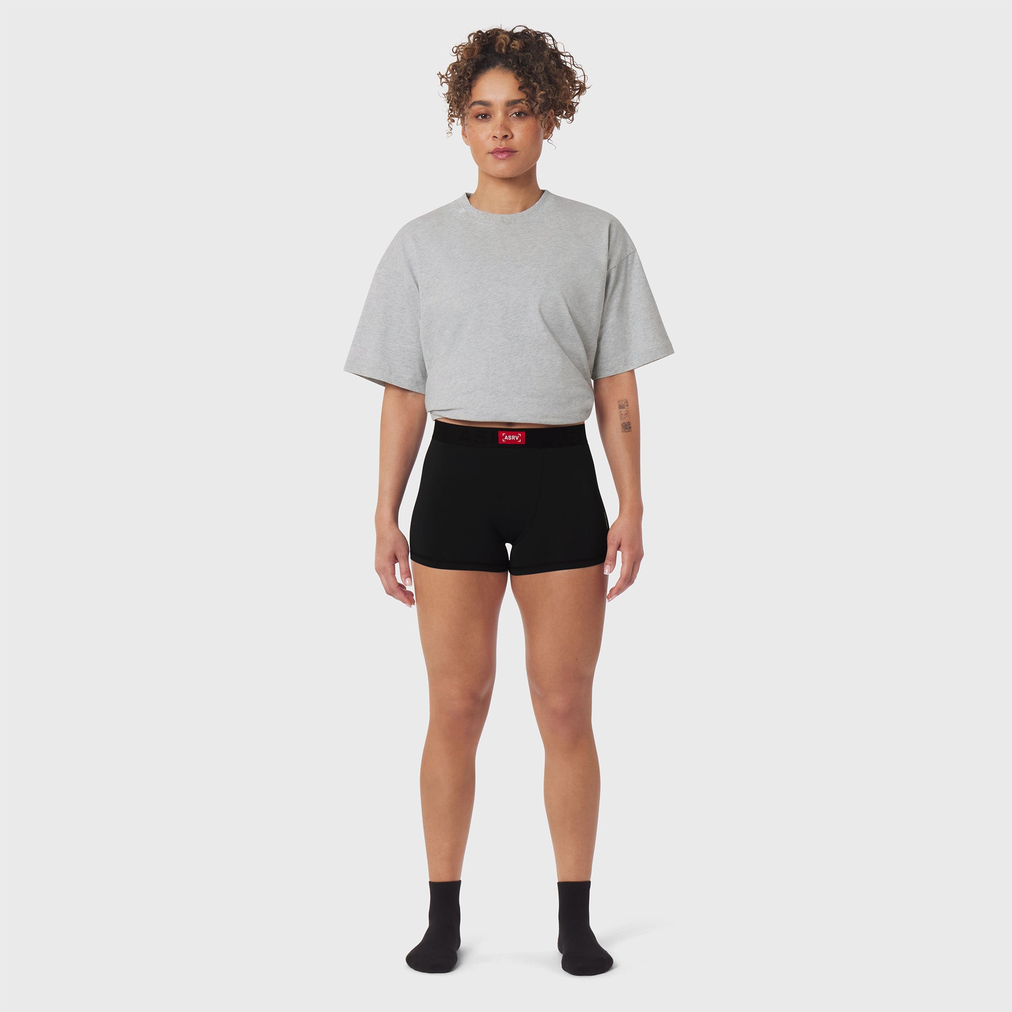 W060. LYCRA® ADAPTIV Briefs in black, worn with grey t-shirt, front view on model