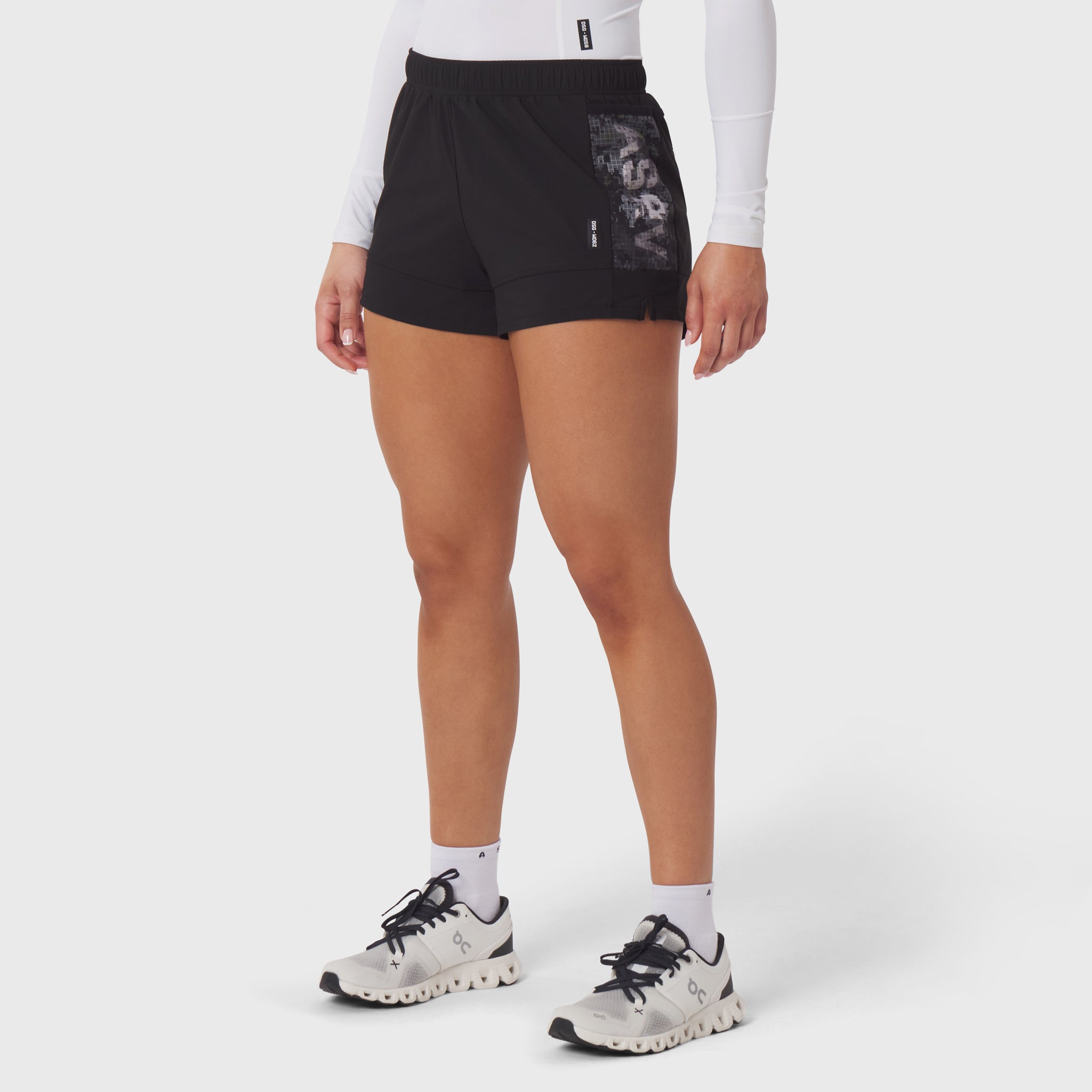 Black Tetra-Lite Adventure Shorts worn with white long-sleeve top and white sneakers, front view