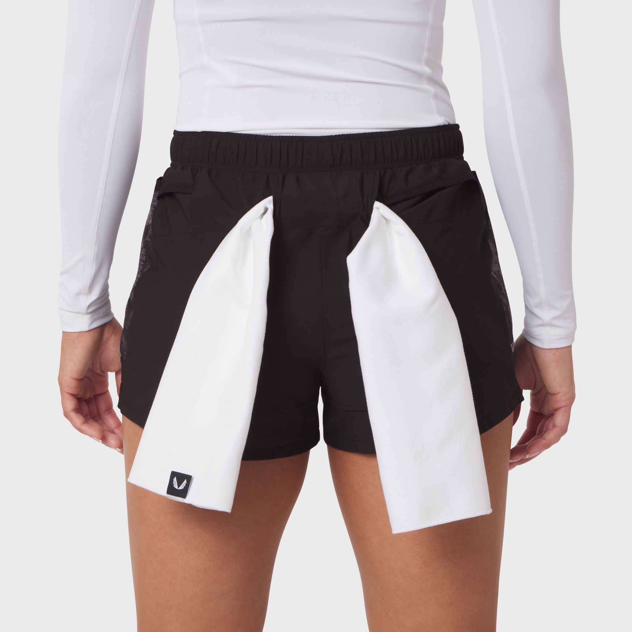Tetra-Lite Adventure Short in black with white panel details, worn by model with white long-sleeve top