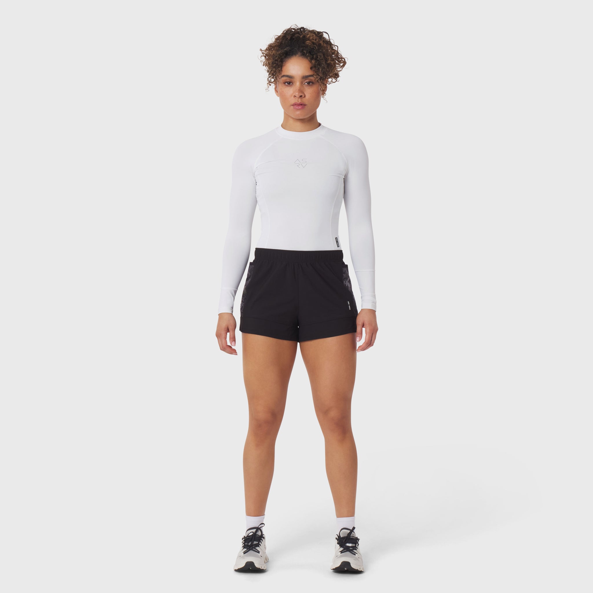 Tetra-Lite Adventure Short in black, worn with white long-sleeve top, front view on model