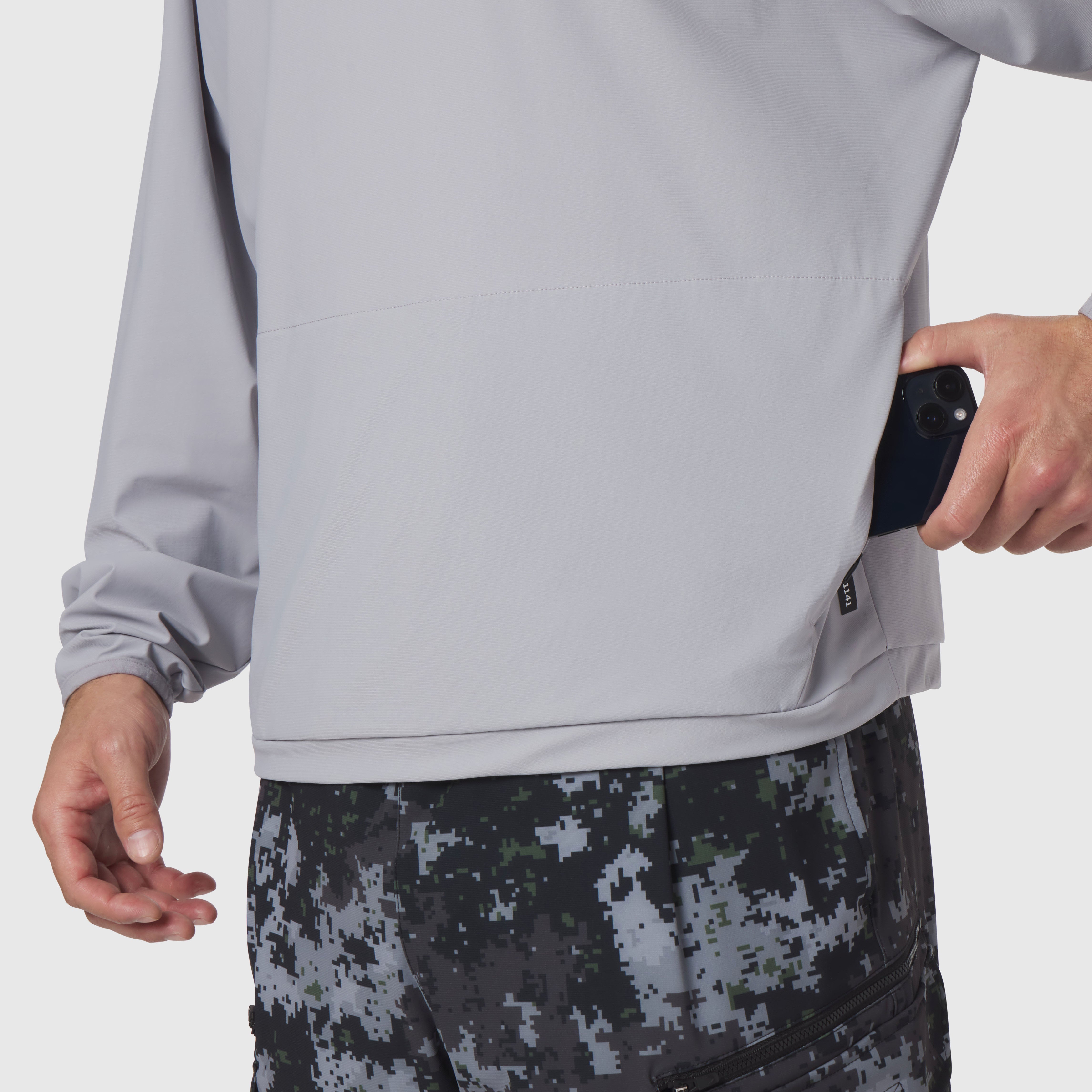 Tetra-Lite Blade Collar Zip Jacket in slate grey, worn by model holding phone