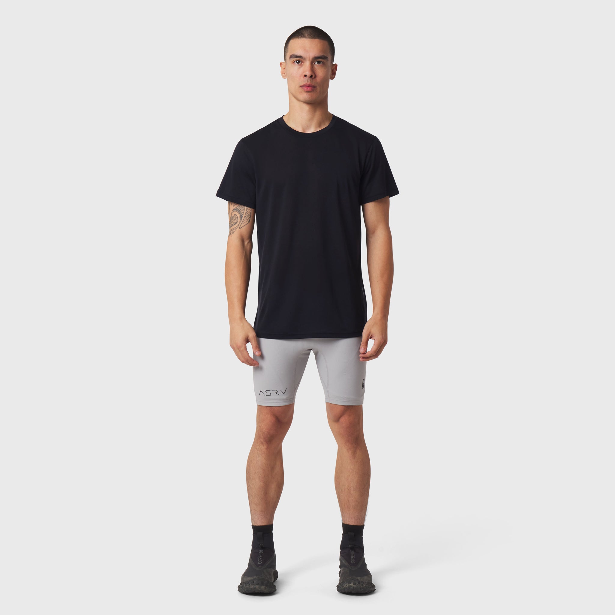 Black Polartec® Delta Training Tee worn with grey shorts and black socks, front view on model