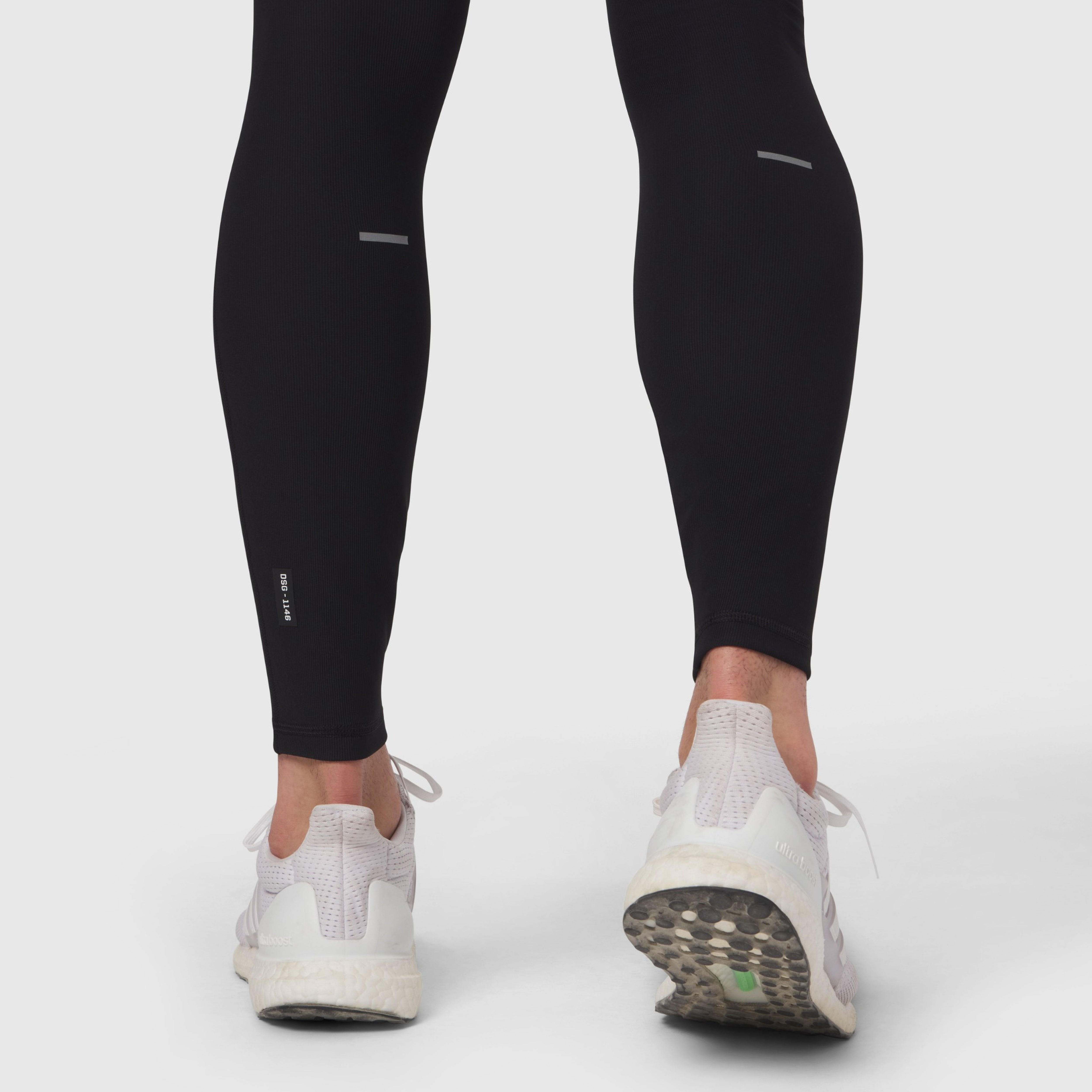 Black Lycra® Ribbed Running Tight worn by model from behind, showing fit and white sneakers