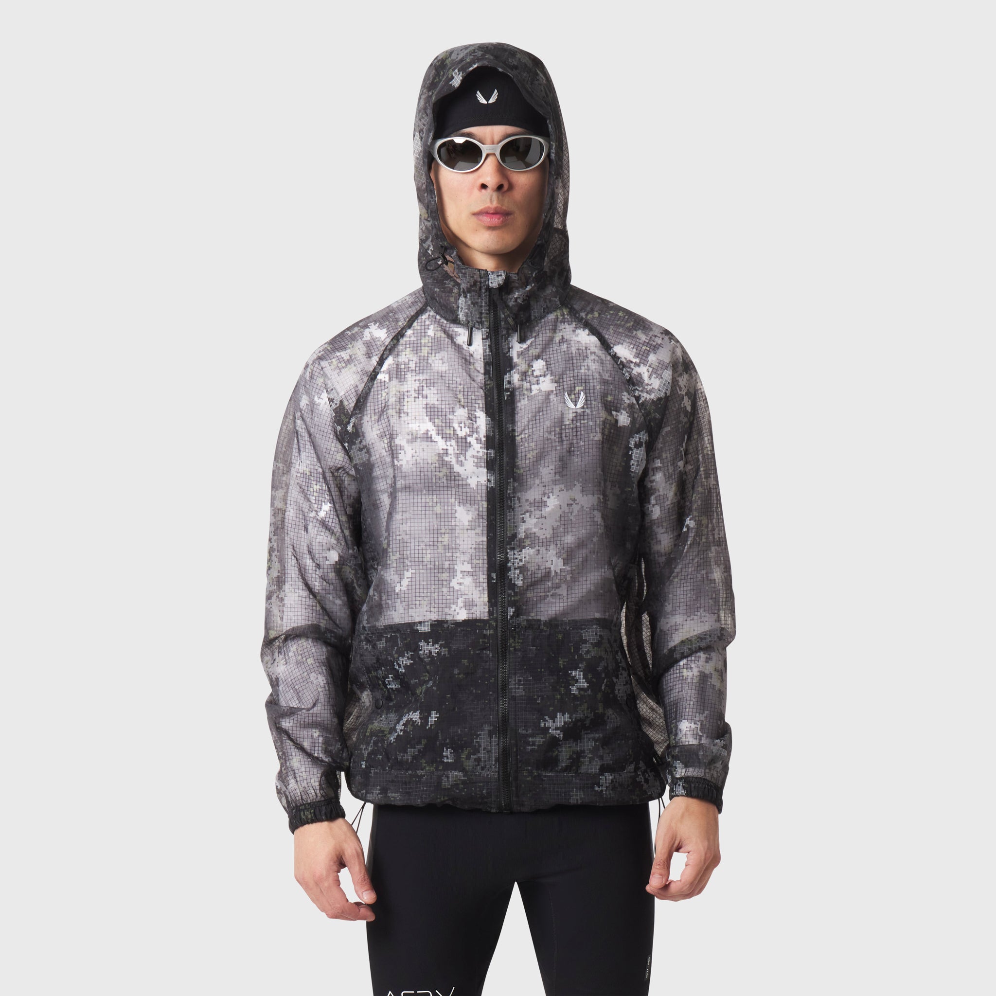 Weather-Ready Transparent Ripstop Shell Jacket in pixel camo, worn by model with hood up