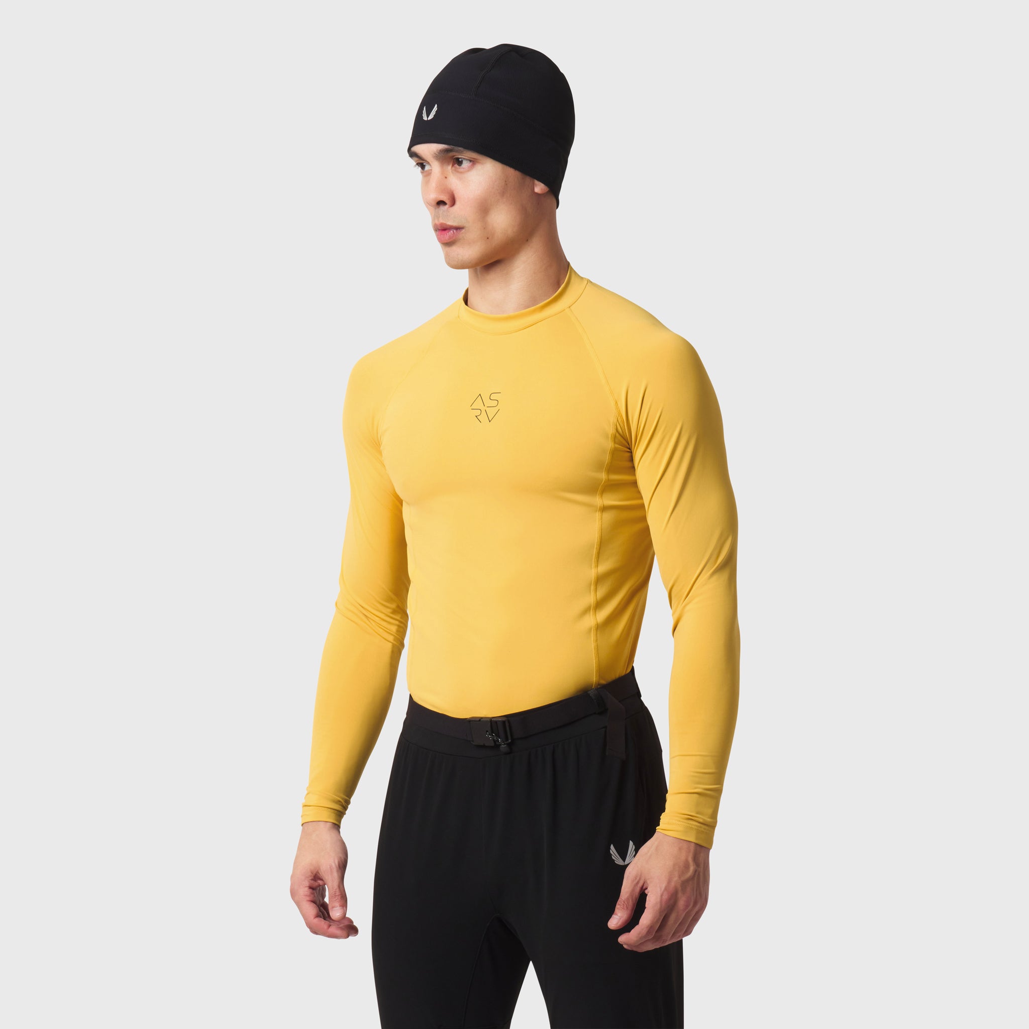 LYCRA® ADAPTIV Baselayer Longsleeve in amber yellow, modeled front view with black beanie and black joggers