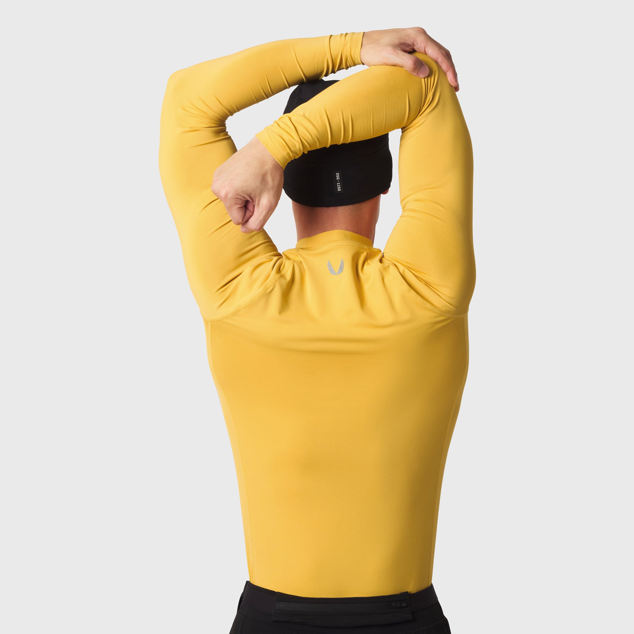 LYCRA® ADAPTIV Baselayer Longsleeve in amber, model wearing with arms raised overhead