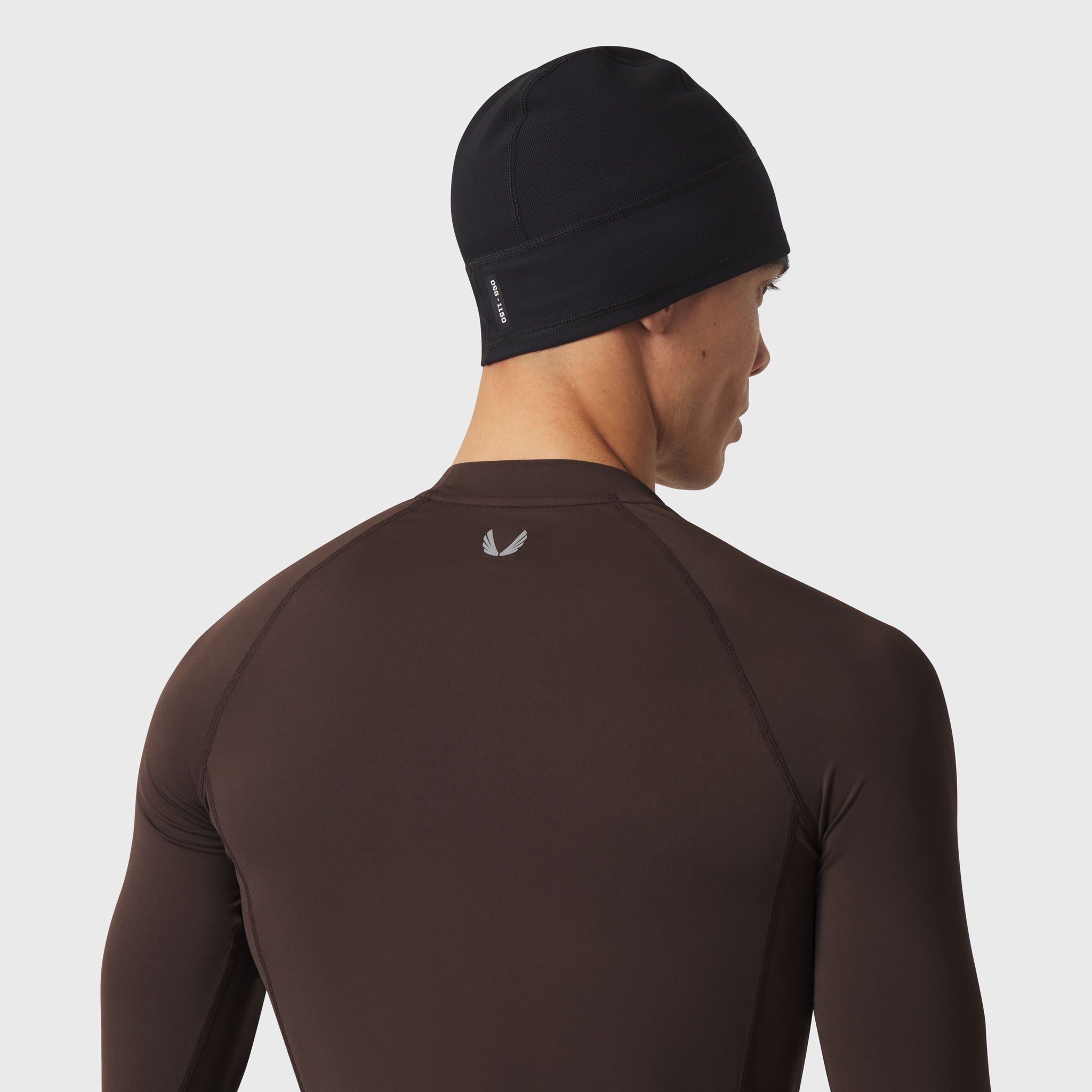LYCRA® ADAPTIV Baselayer Longsleeve in dark brown, worn by model from back view with black beanie