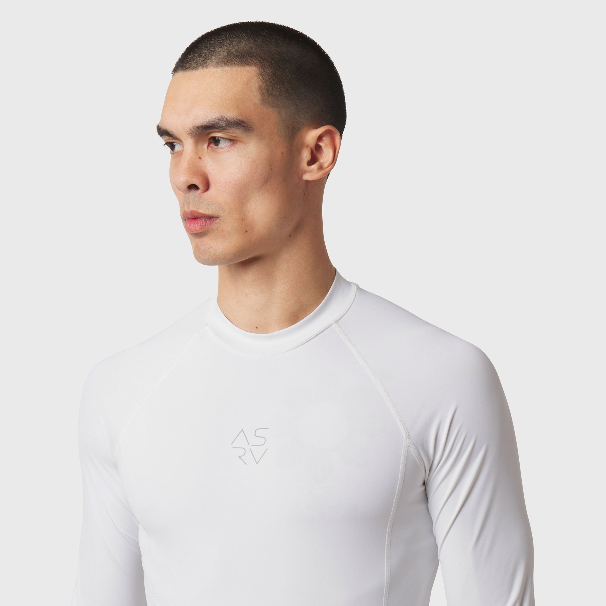LYCRA® ADAPTIV baselayer longsleeve in white, worn by model in profile view