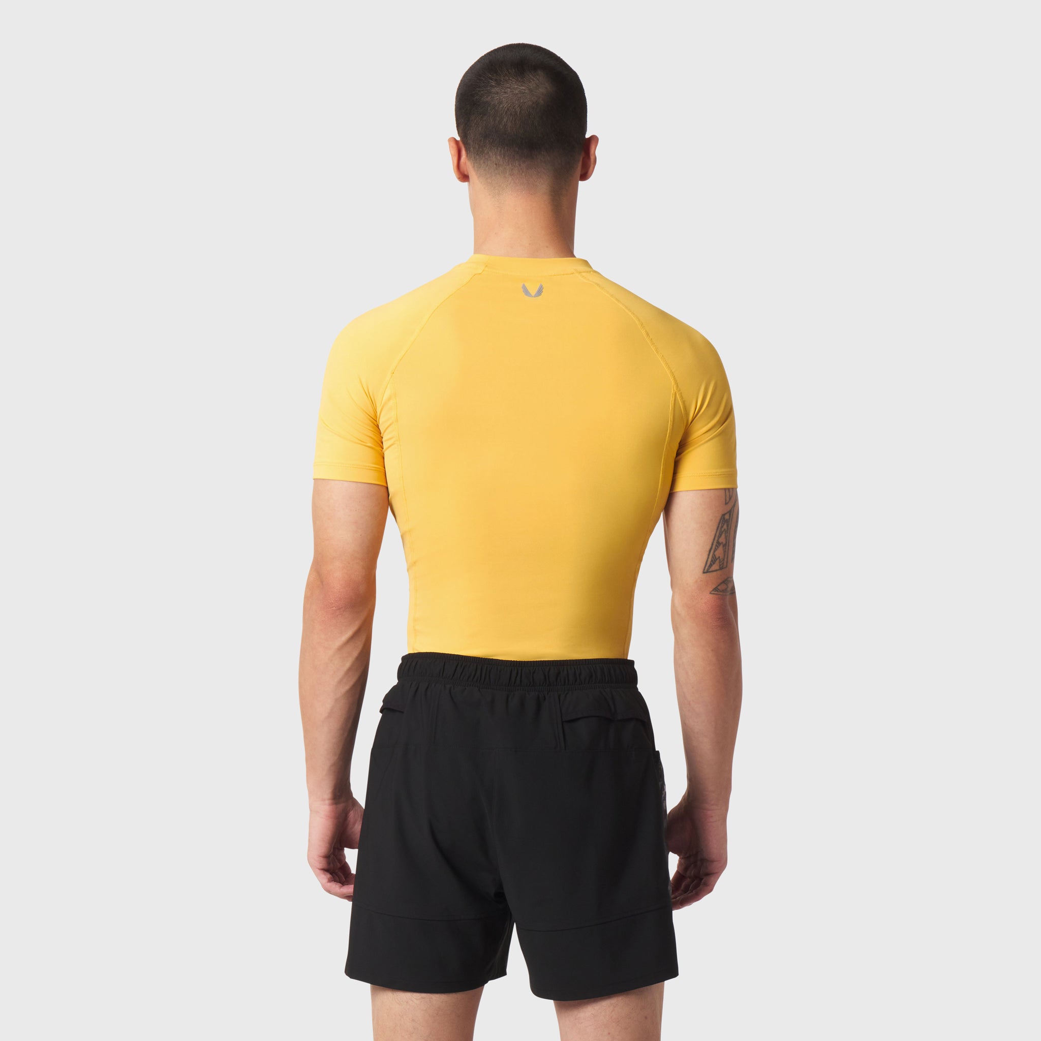 LYCRA® ADAPTIV Baselayer Shortsleeve in amber yellow, back view on model