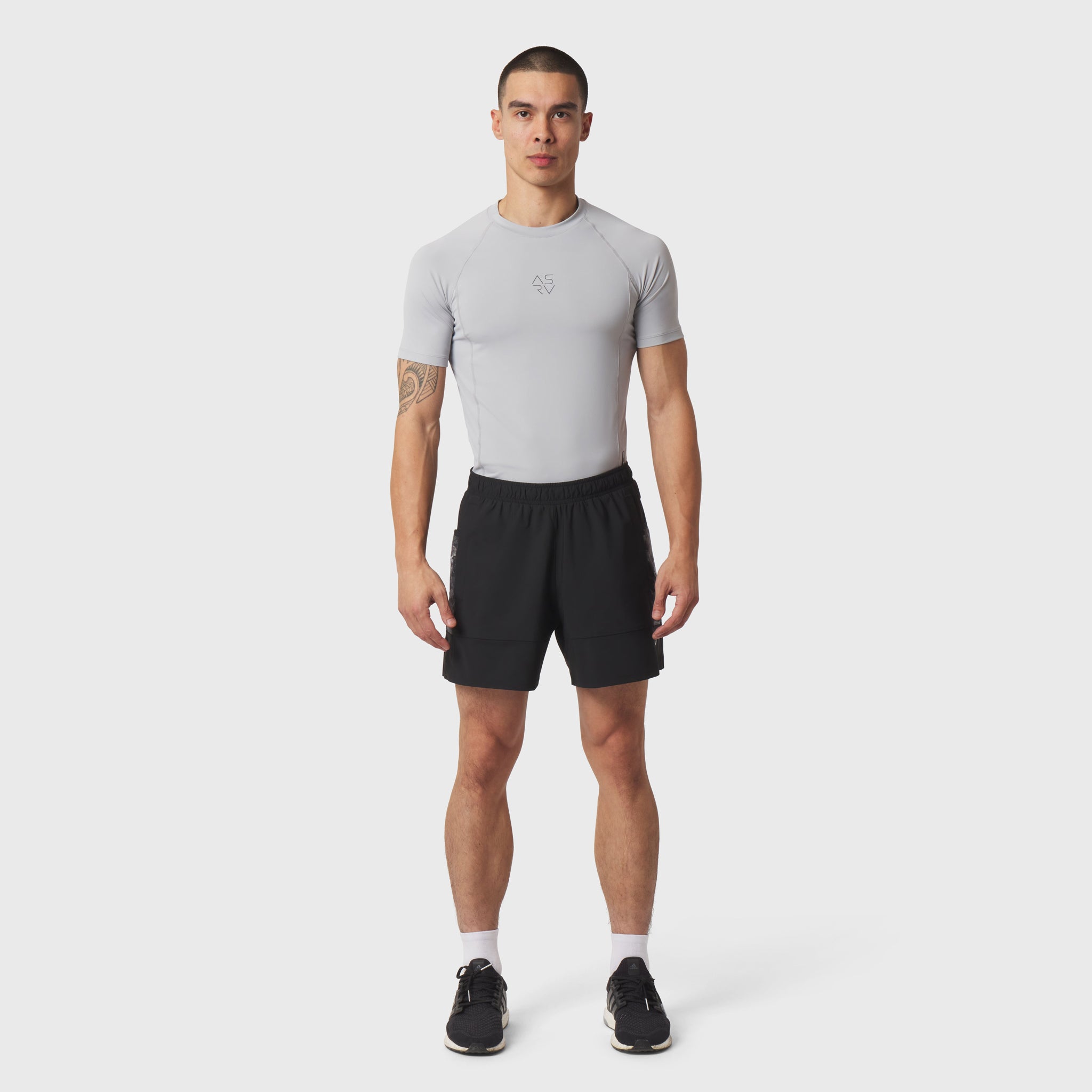 LYCRA® ADAPTIV baselayer shortsleeve tee in light grey, worn with black shorts, front view on model