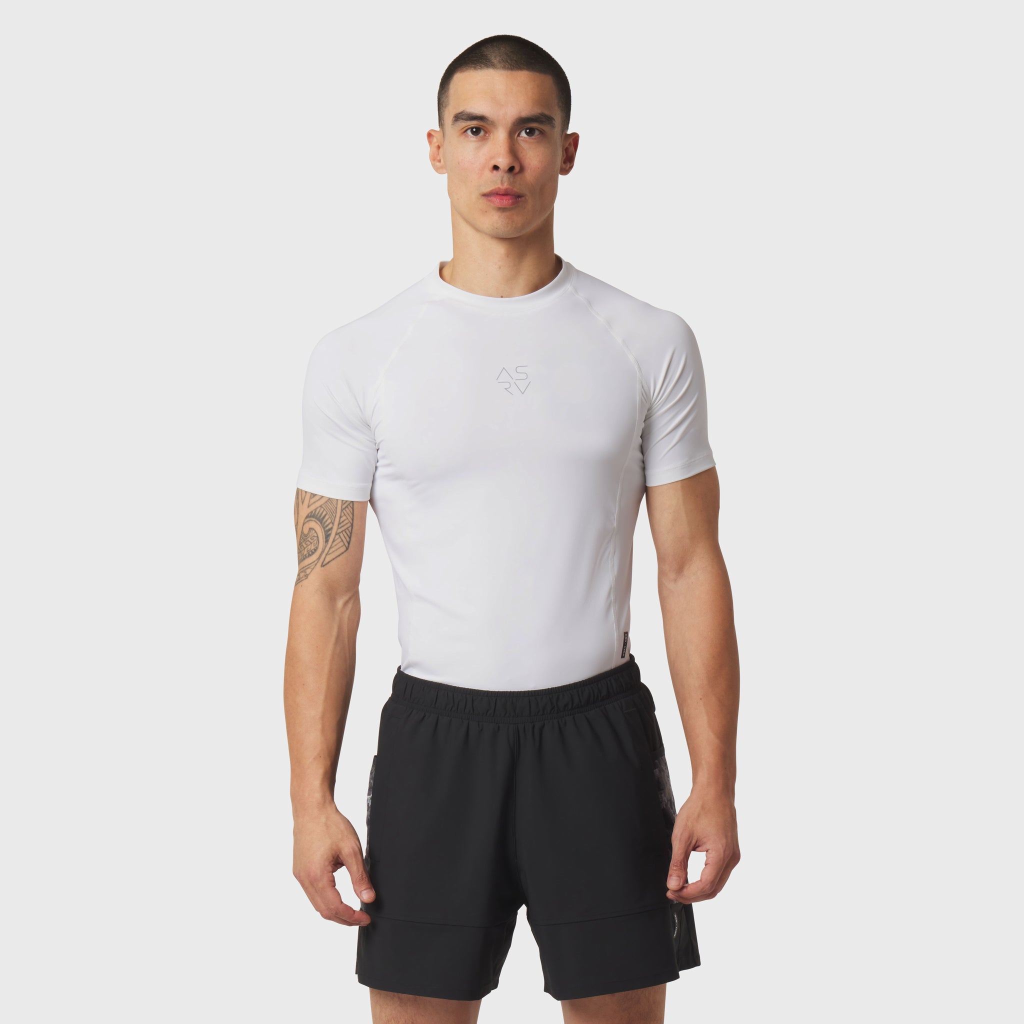 White LYCRA® ADAPTIV baselayer shortsleeve t-shirt worn with black shorts, front view on model