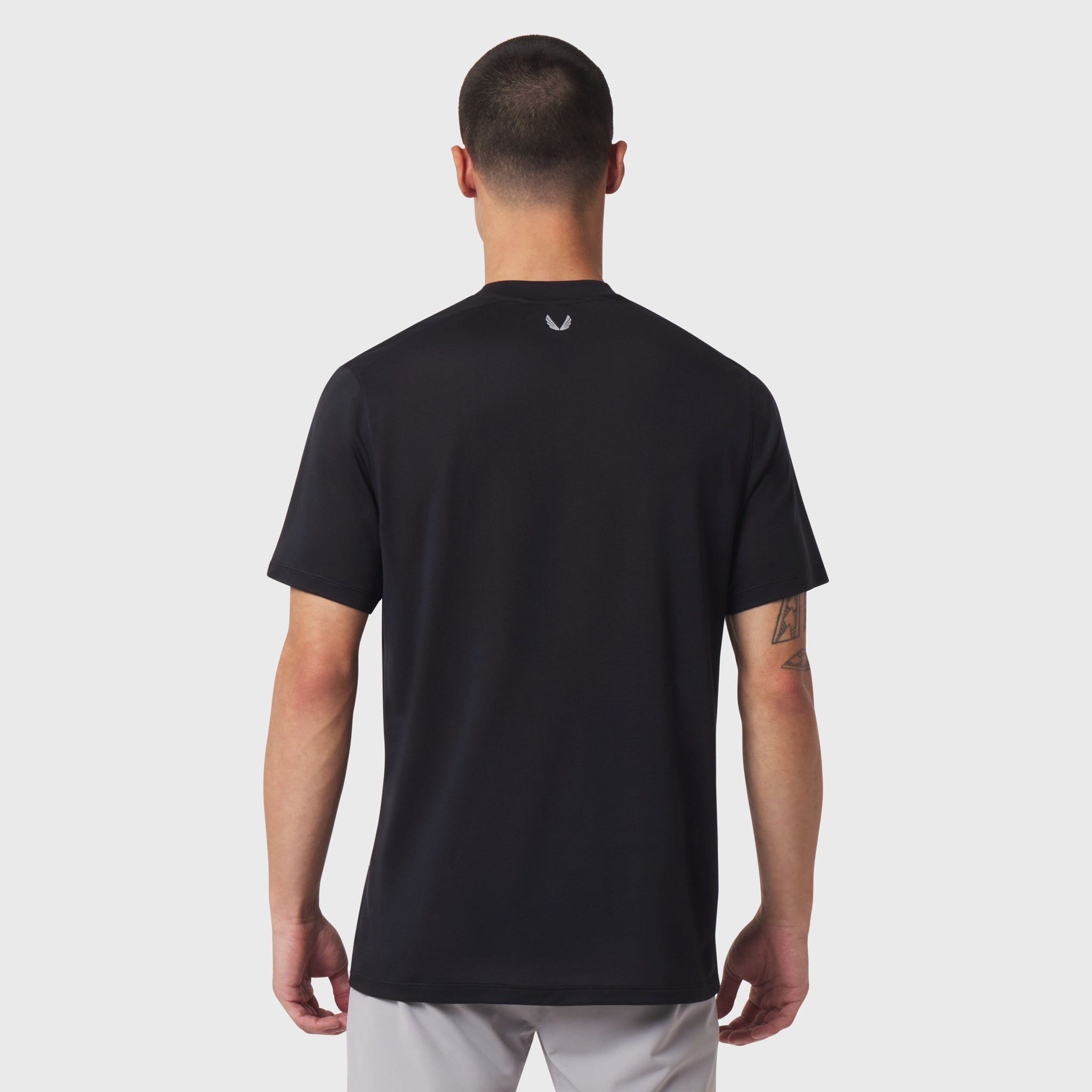 Black short-sleeve polo shirt worn by model, back view