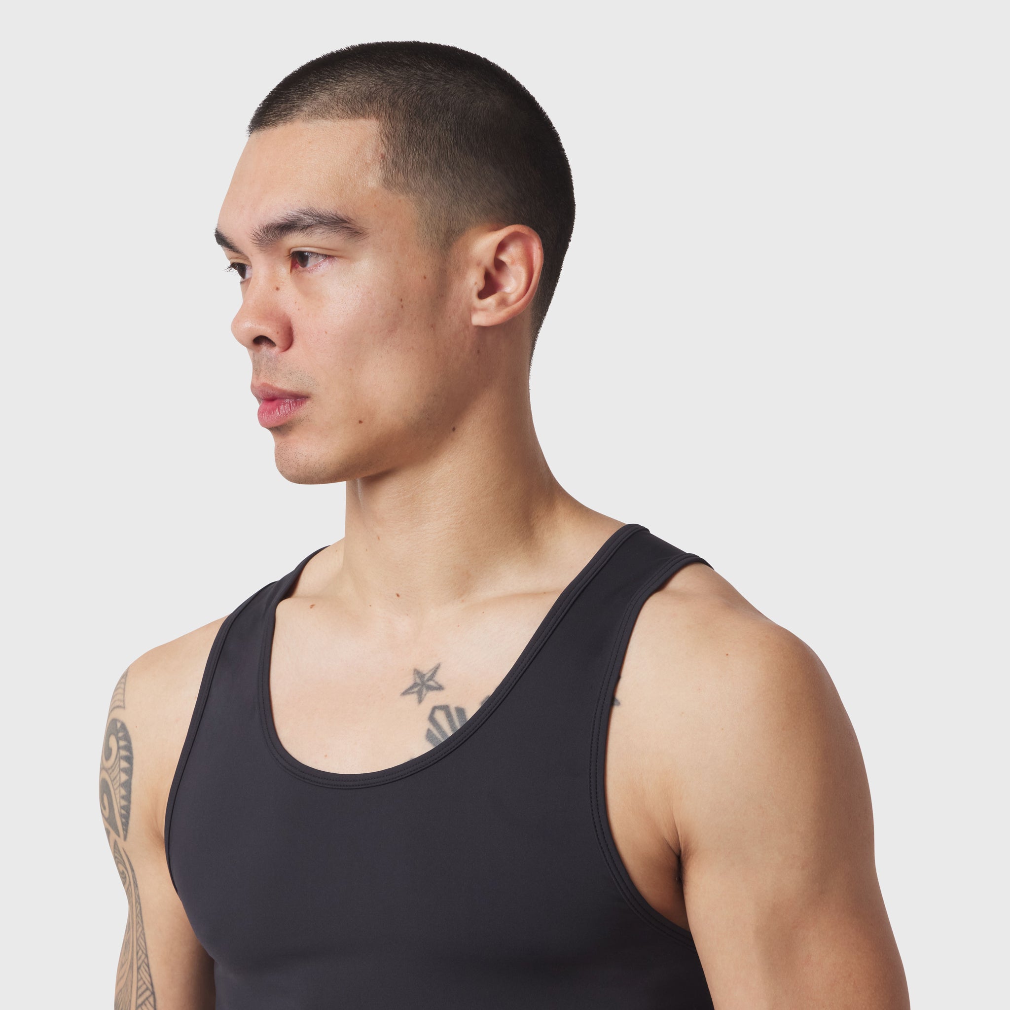 Black LYCRA® ADAPTIV Baselayer Tank worn by male model, side profile view
