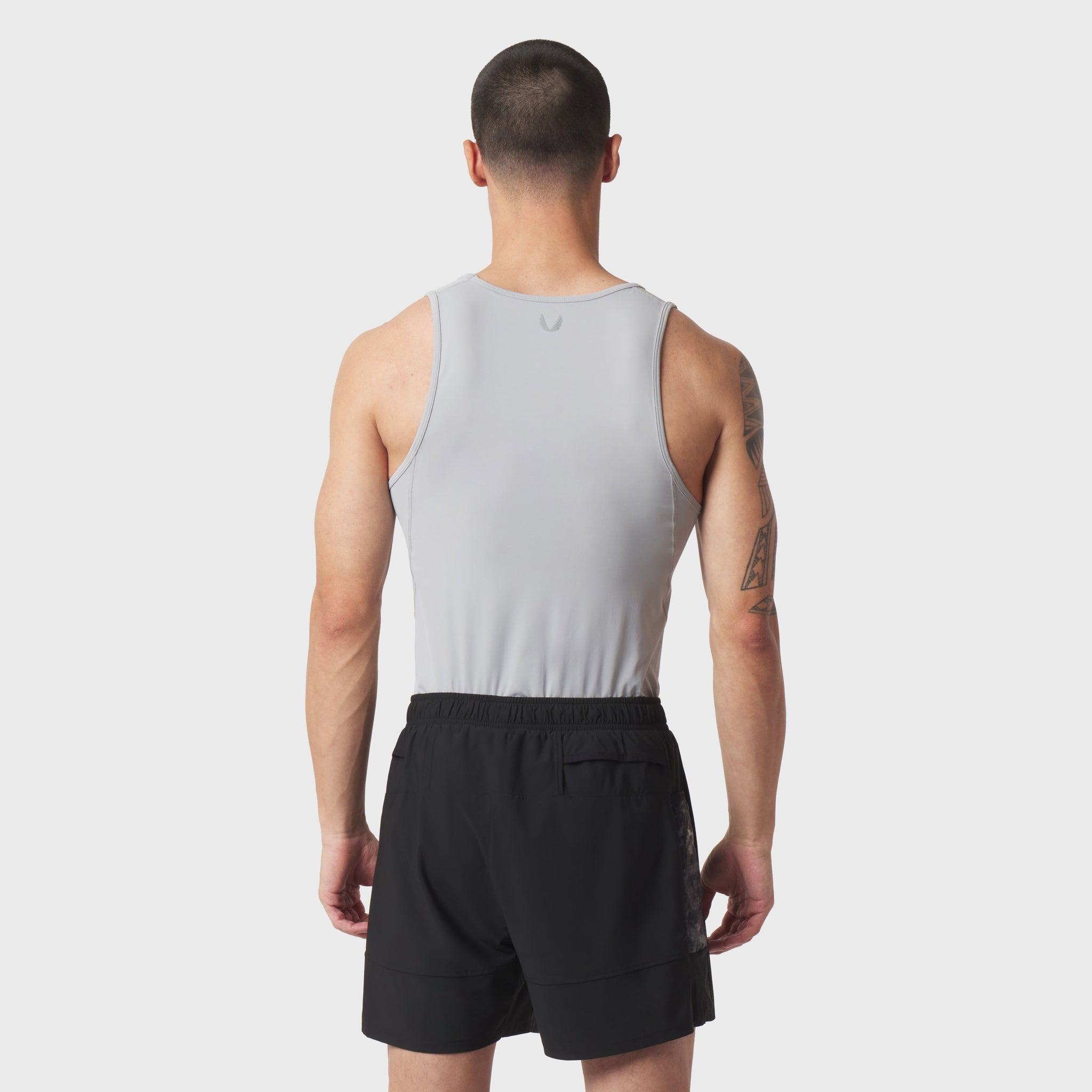 LYCRA® ADAPTIV Baselayer Tank in slate grey worn with black shorts, back view