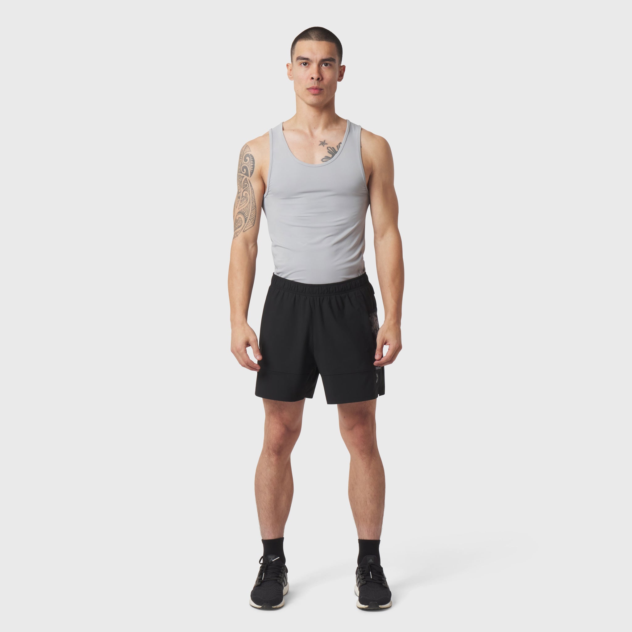 LYCRA® ADAPTIV Baselayer Tank in slate grey, worn with black shorts, front view on model