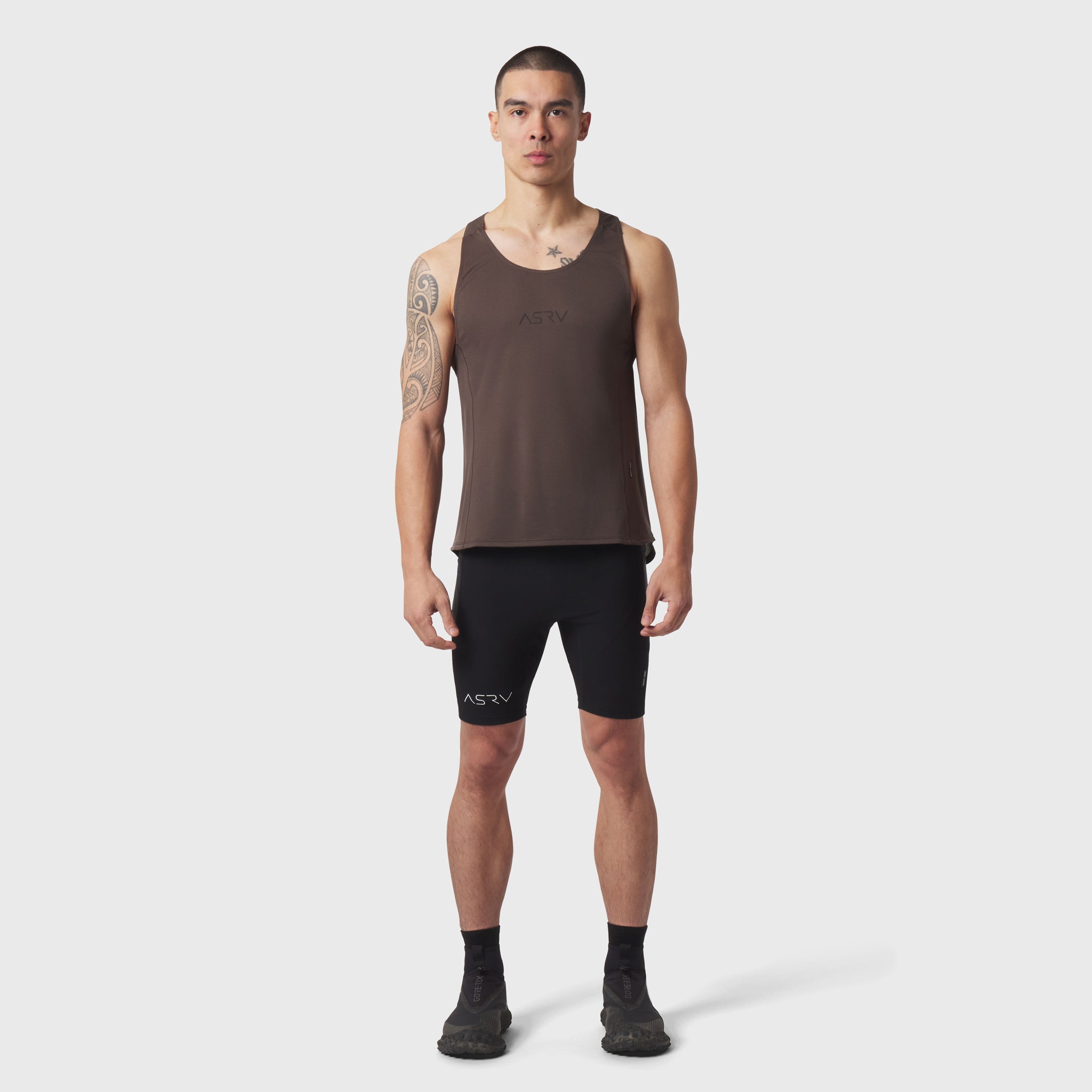 Polartec® Delta Singlet in dark earth worn by male model with black shorts, front view