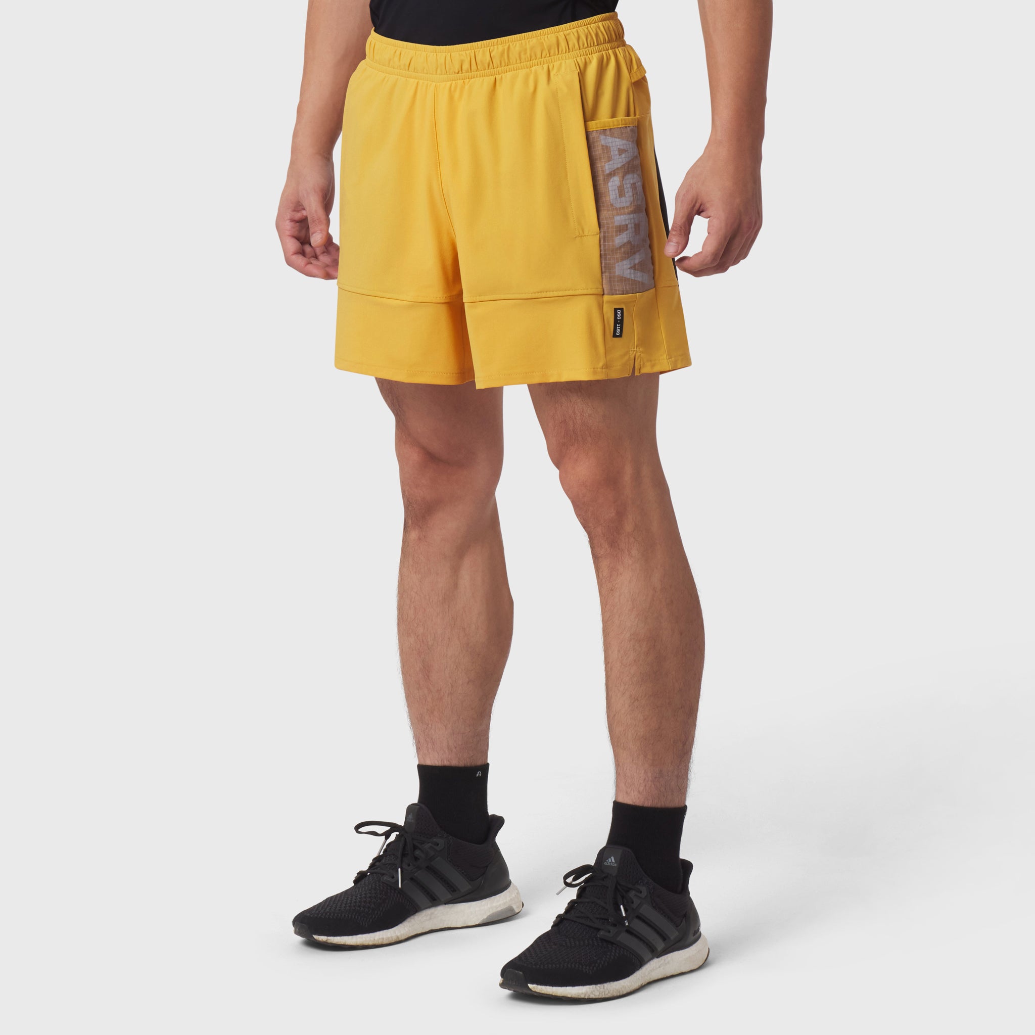Tetra-Lite® Adventure Short in amber yellow, worn by model with black socks and sneakers