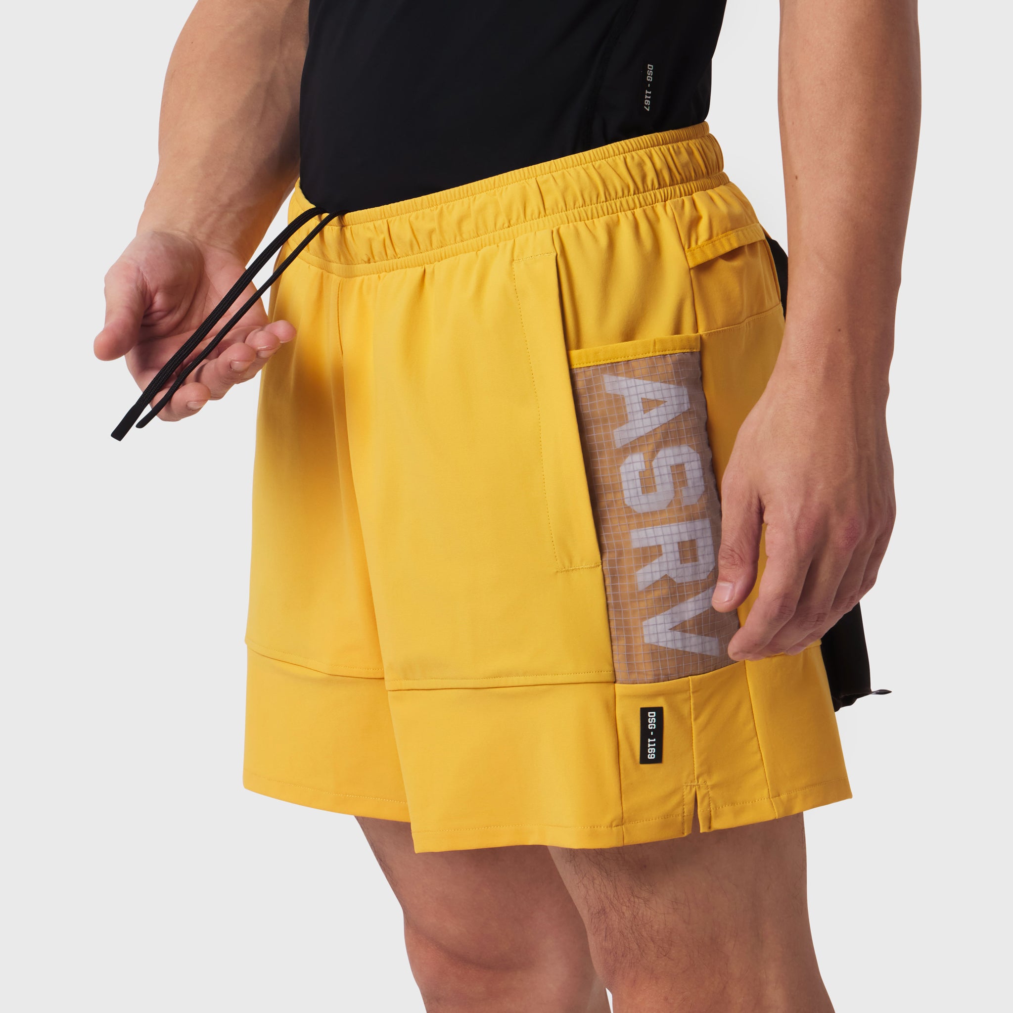 Tetra-Lite Adventure Short in amber yellow, worn by model holding drawstring, side view