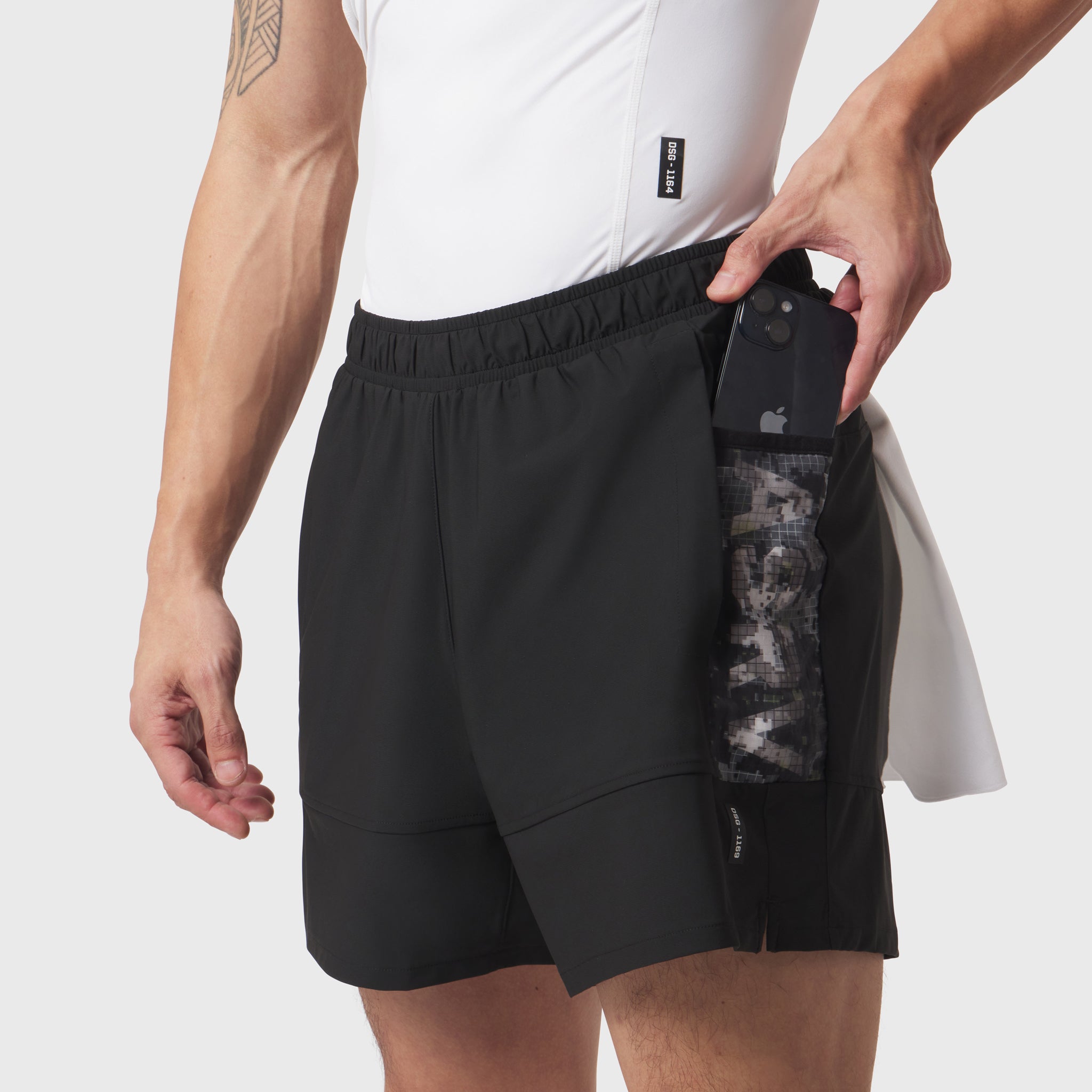 Tetra-Lite Adventure Short in black worn by model, demonstrating side pocket with phone storage