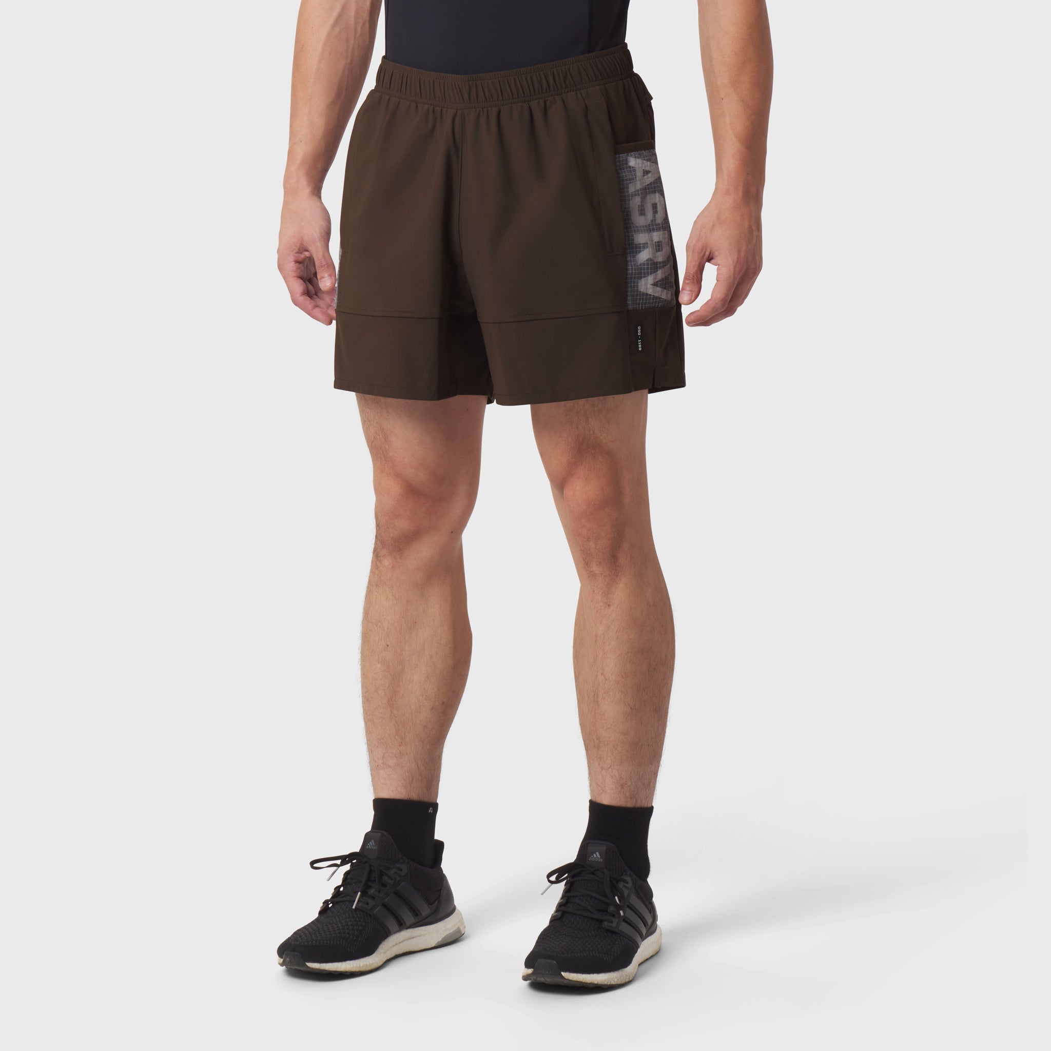 Tetra-Lite Adventure Short in Dark Earth, modeled front view with black socks and sneakers