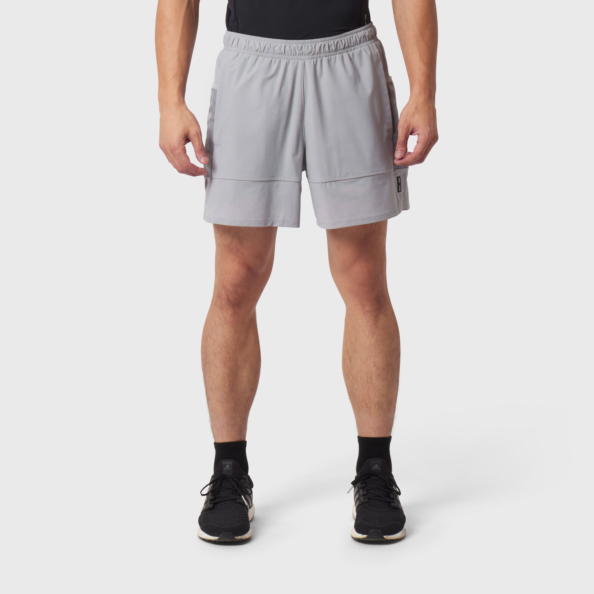 Tetra-Lite Adventure Short in slate grey, modeled from front with black socks and sneakers