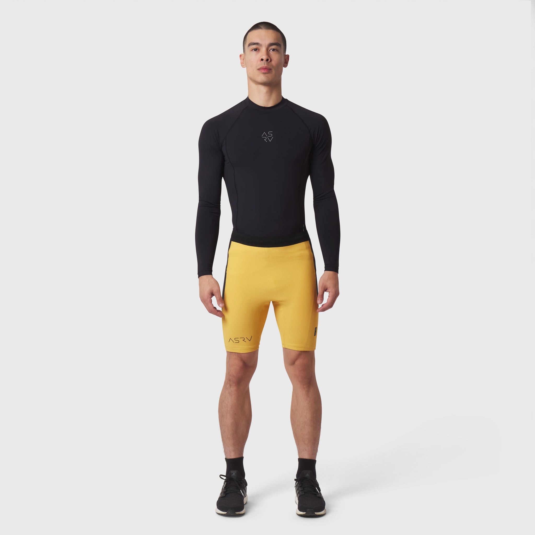 Lycra Ribbed Run Half-Tight in amber yellow worn by male model with black long-sleeve top, front view