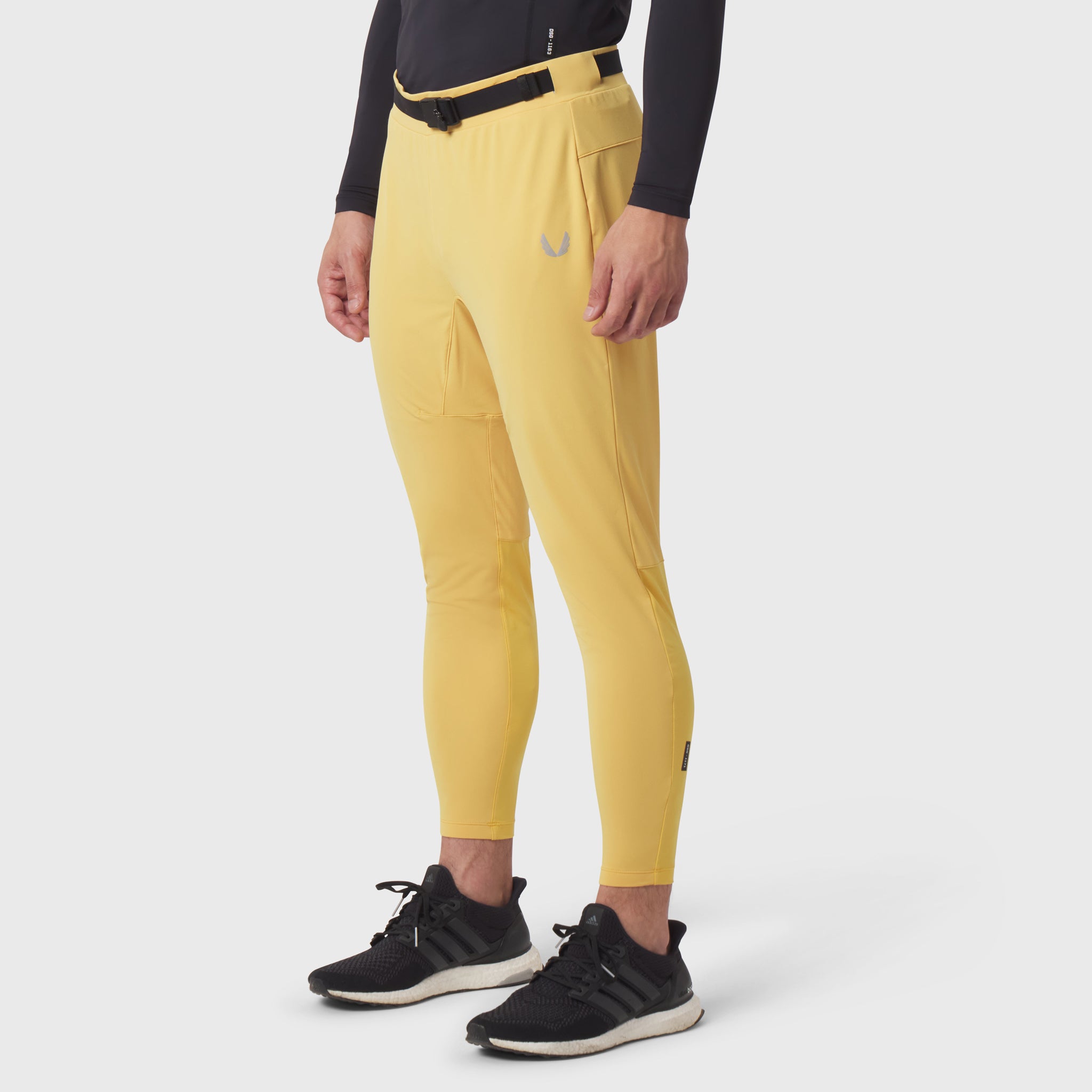 Hybrid Belt-Pack Run Jogger in amber yellow worn by model with black long-sleeve top and black sneakers, side view