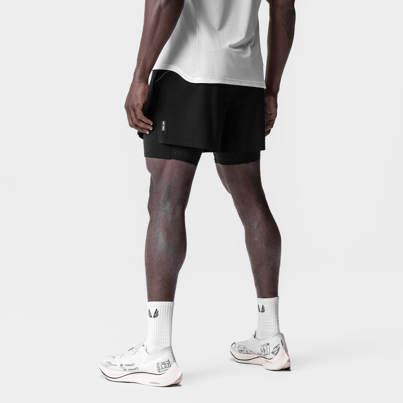 Aerotex 4" High Split Liner Short in black, worn by model from behind, paired with white socks and sneakers