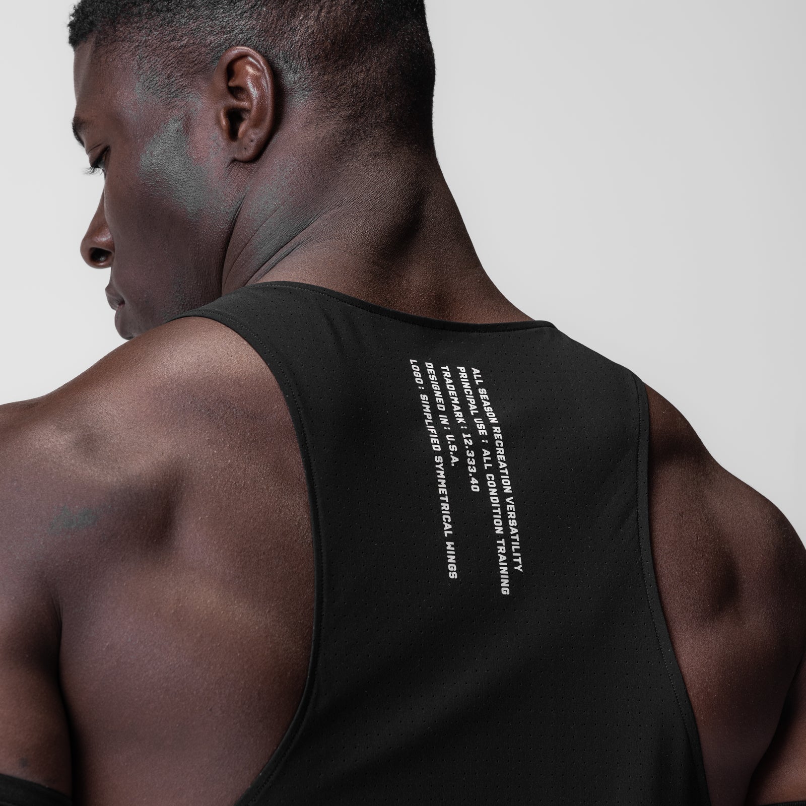 Laser-Vent™ Singlet Tank in black with white text, worn by model, back view