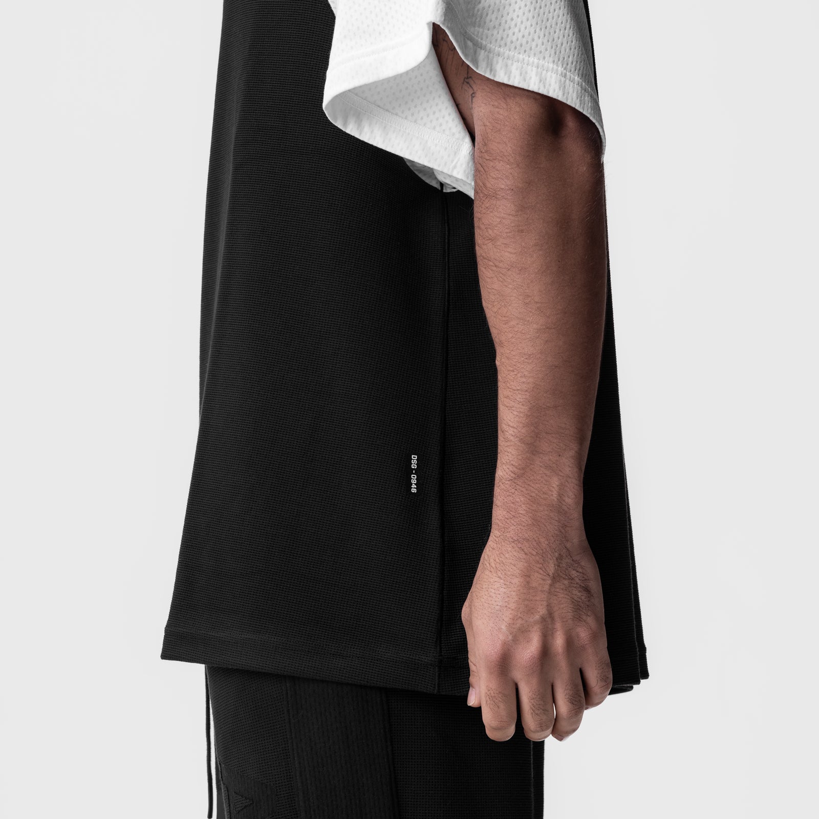 Waffle knit oversized tee in black and white, worn by model showing side view
