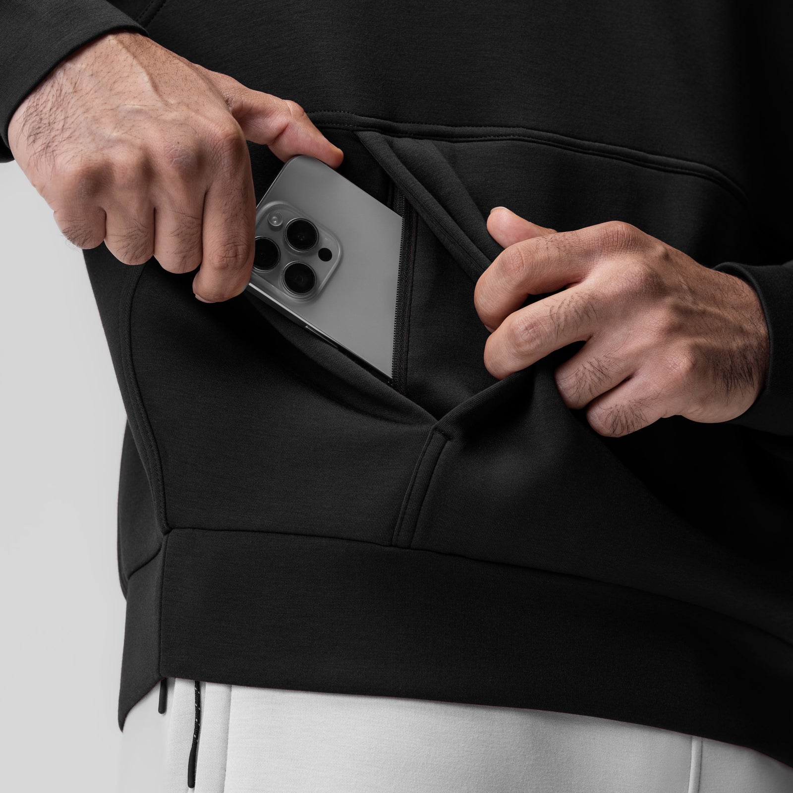 Black Dri-Core Oversized Crewneck worn by model, detail shot of phone in kangaroo pocket