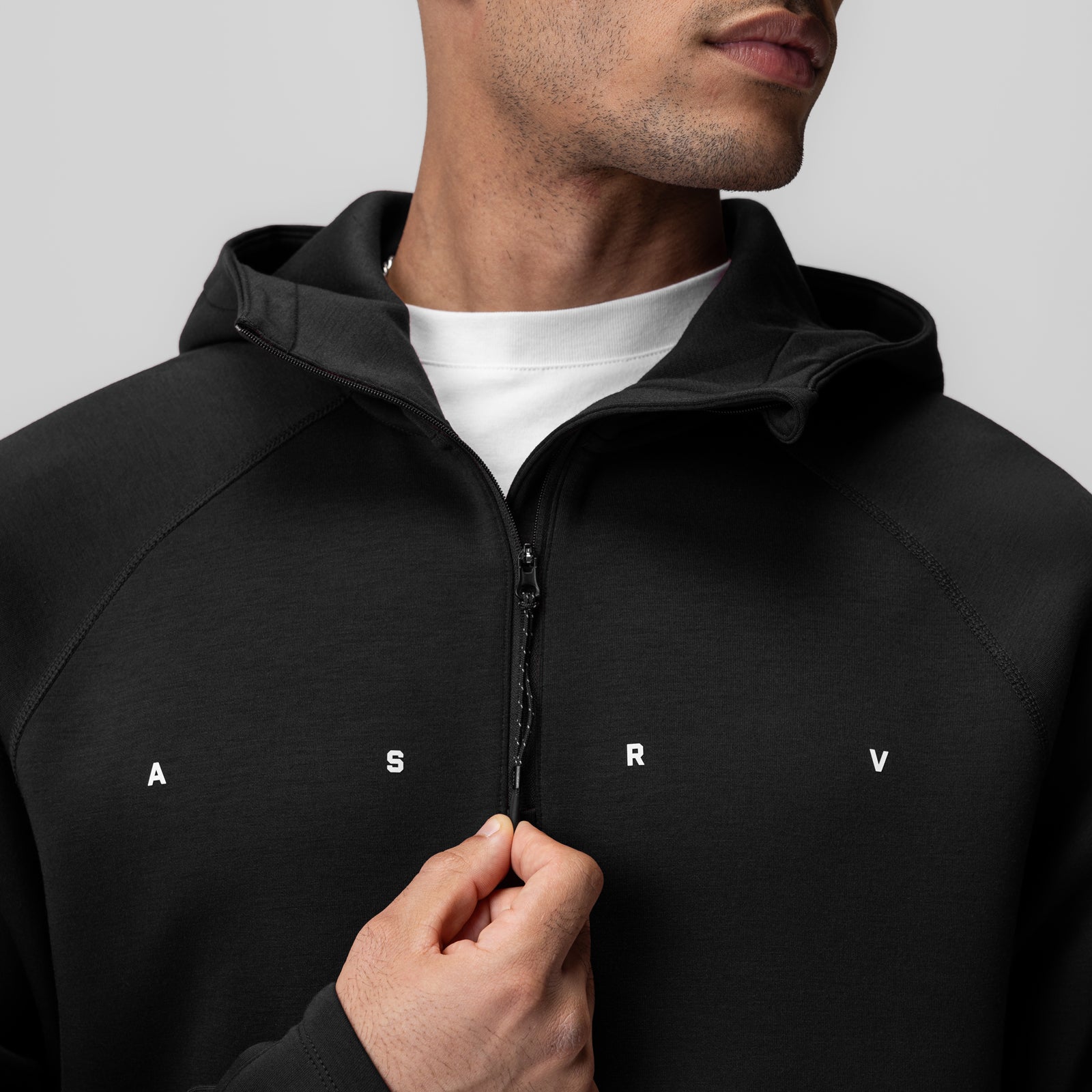 Black Dri-Core™ Zip Hoodie worn by model, front view with hand on zipper