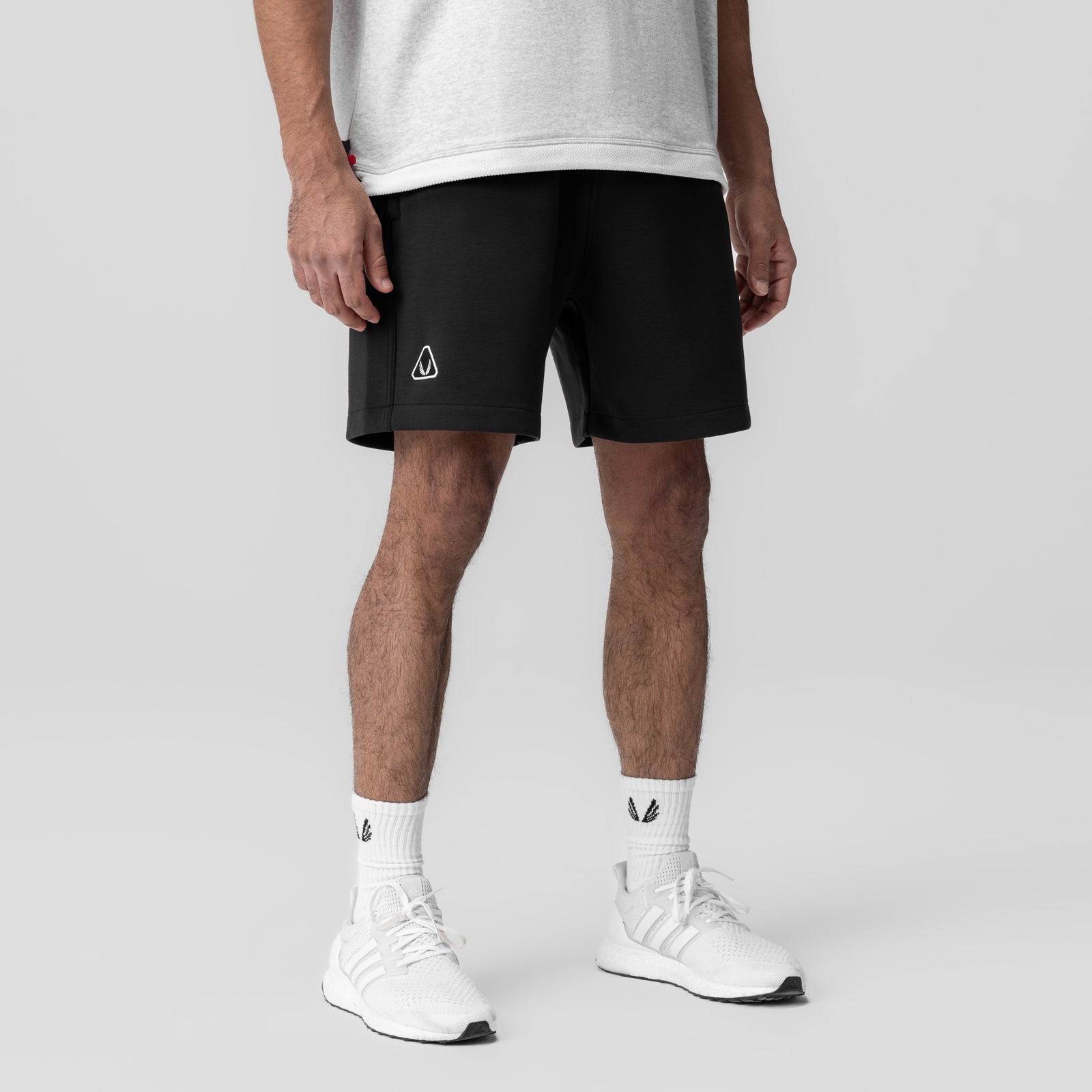 Dri-Core Training Short in black, worn with white socks and sneakers, front view