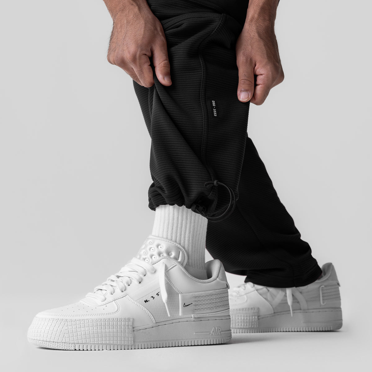 Black Deltapeak® Cargo Cinch Jogger worn with white socks and sneakers, side view