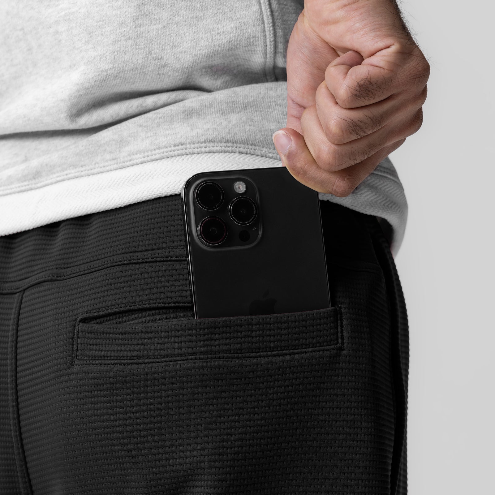 Black Deltapeak® Straight Leg Sweats worn by model, side view with phone in pocket
