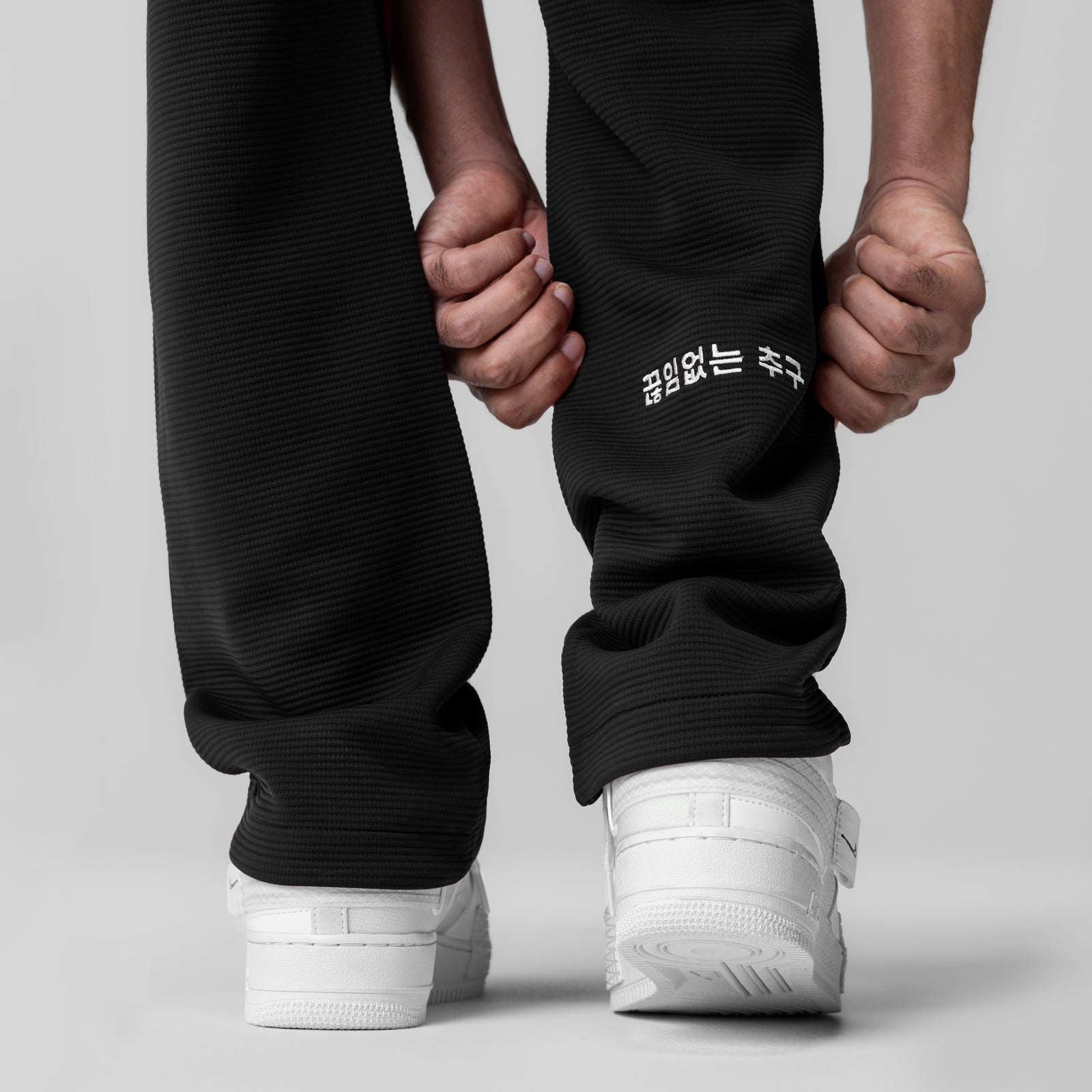 Deltapeak® Straight Leg Sweats in black worn by model, back view showing white sneakers