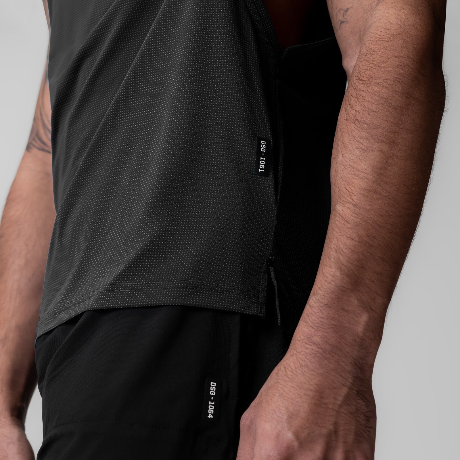 Ice-Skin™ Muscle Tank in black worn by model, side view showing fit and fabric detail