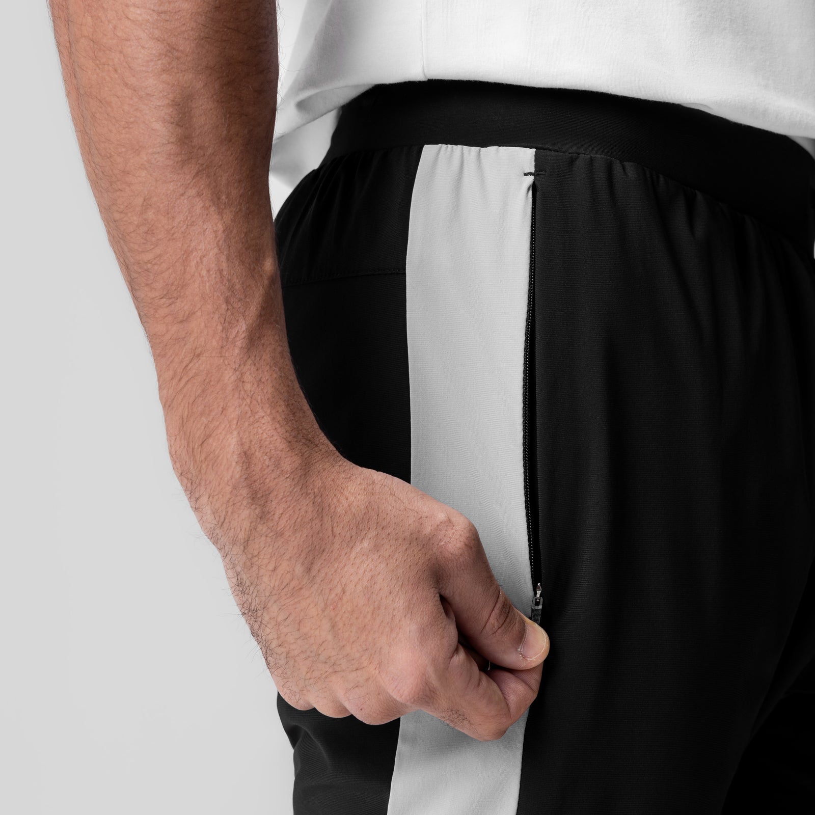 Tetra-Lite Cuffed Training Jogger in black with white stripe, worn by model with hand in pocket