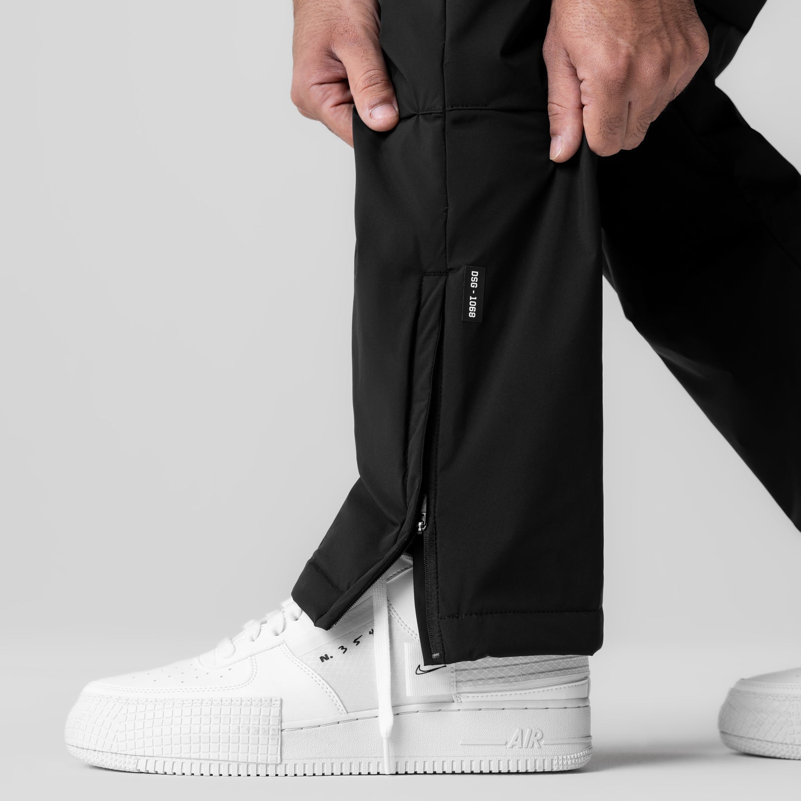 Aerotex PrimaLoft Warm-Up Pant in black, worn with white sneakers, detail shot of leg and zipper