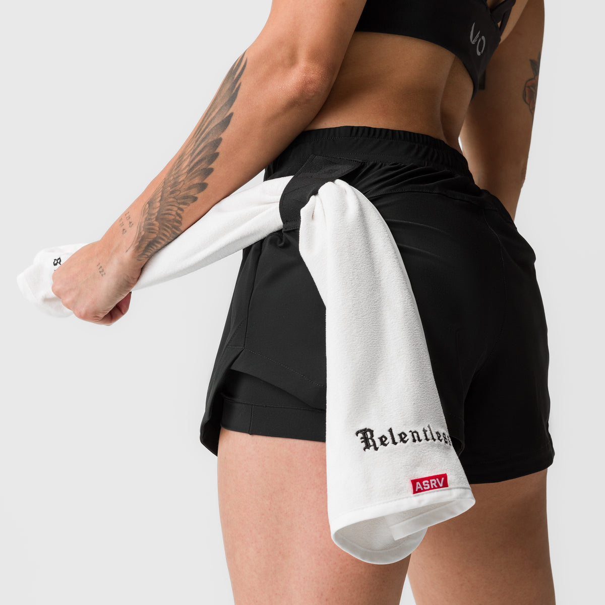 Black Tetra-Lite 4" liner shorts with white towel, worn by model with visible tattoos