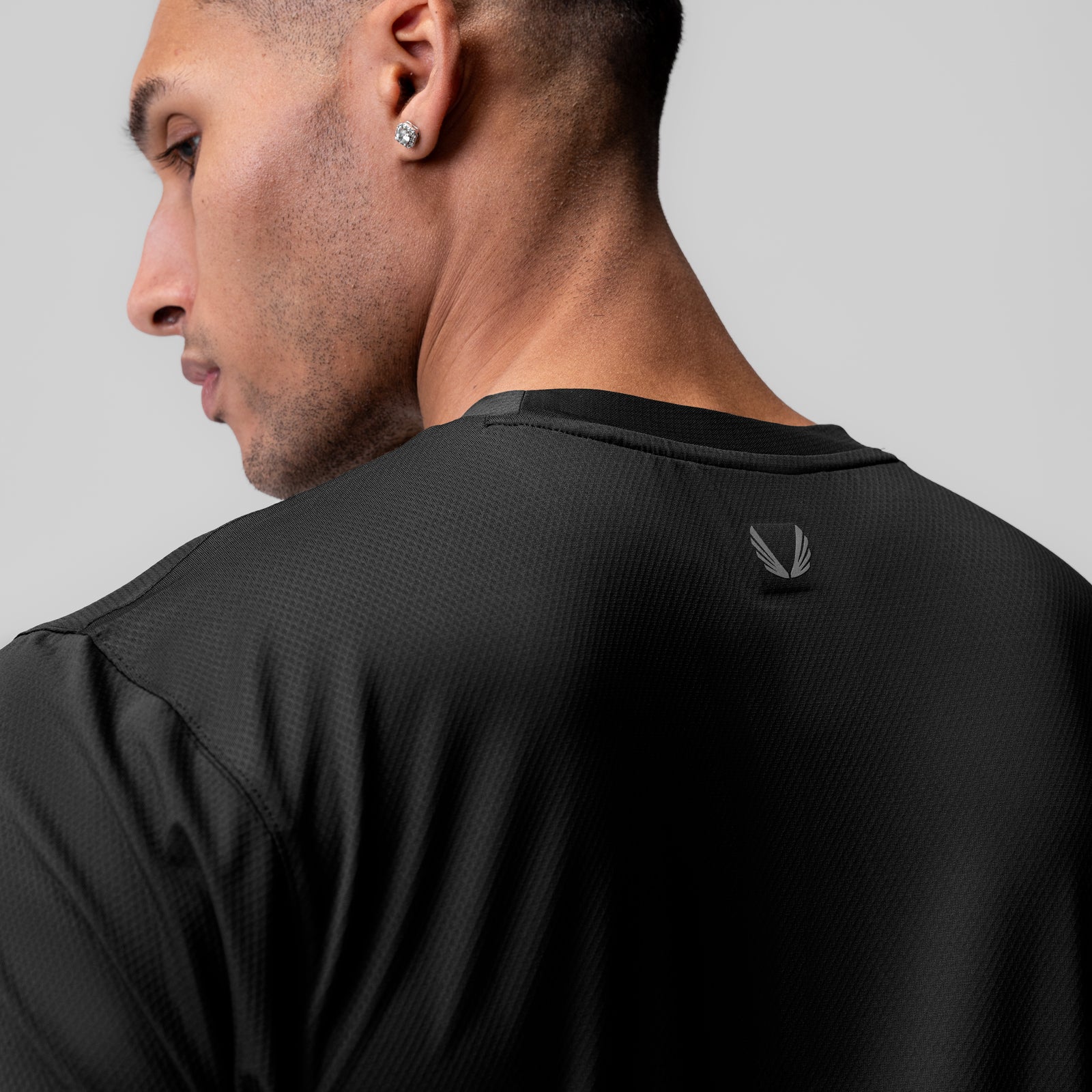 AeroSilver® Essential Tee in black, worn by model shown from side profile view