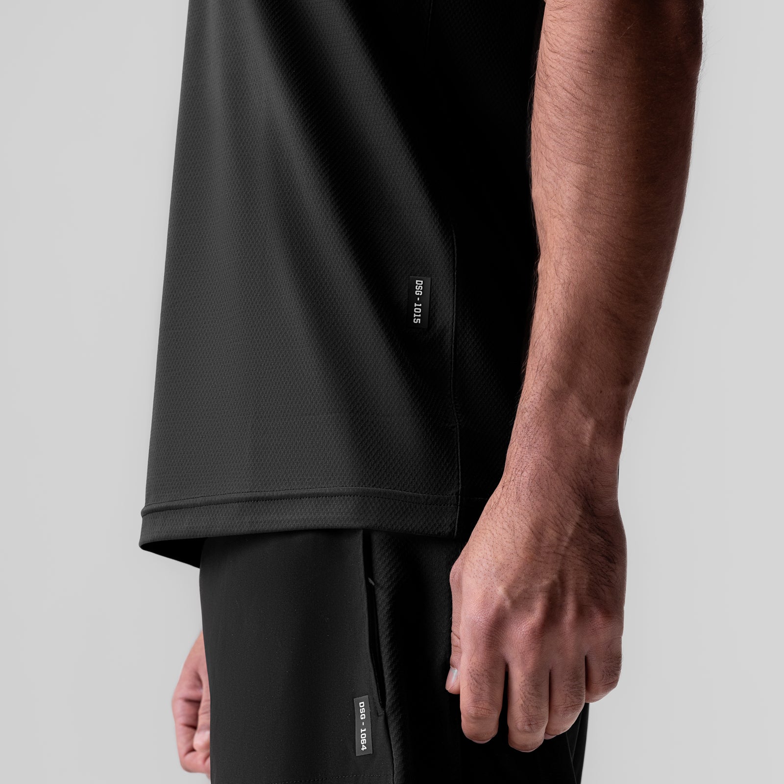 Black AeroSilver Essential Tee worn by model, side view showing fit and fabric texture