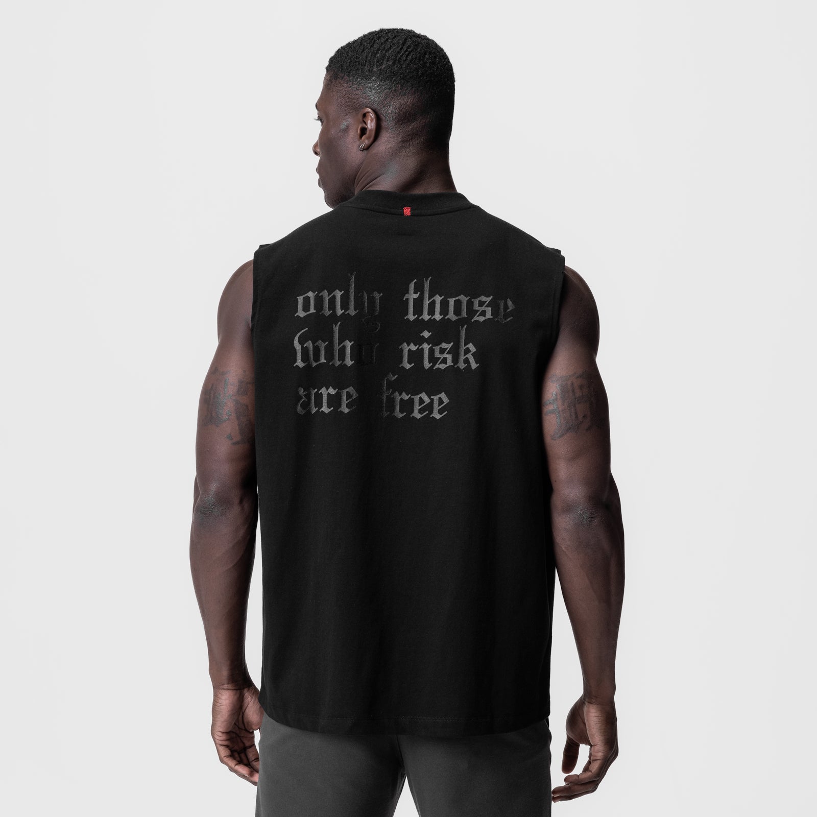 Black Tech Essential Relaxed Cutoff tank top worn by model, back view showing OTWR graphic
